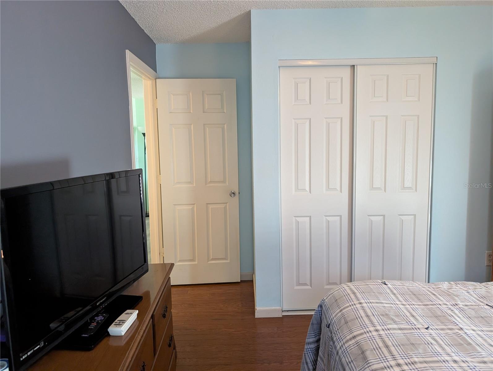 View of guest bedroom entry from hallway and closet.