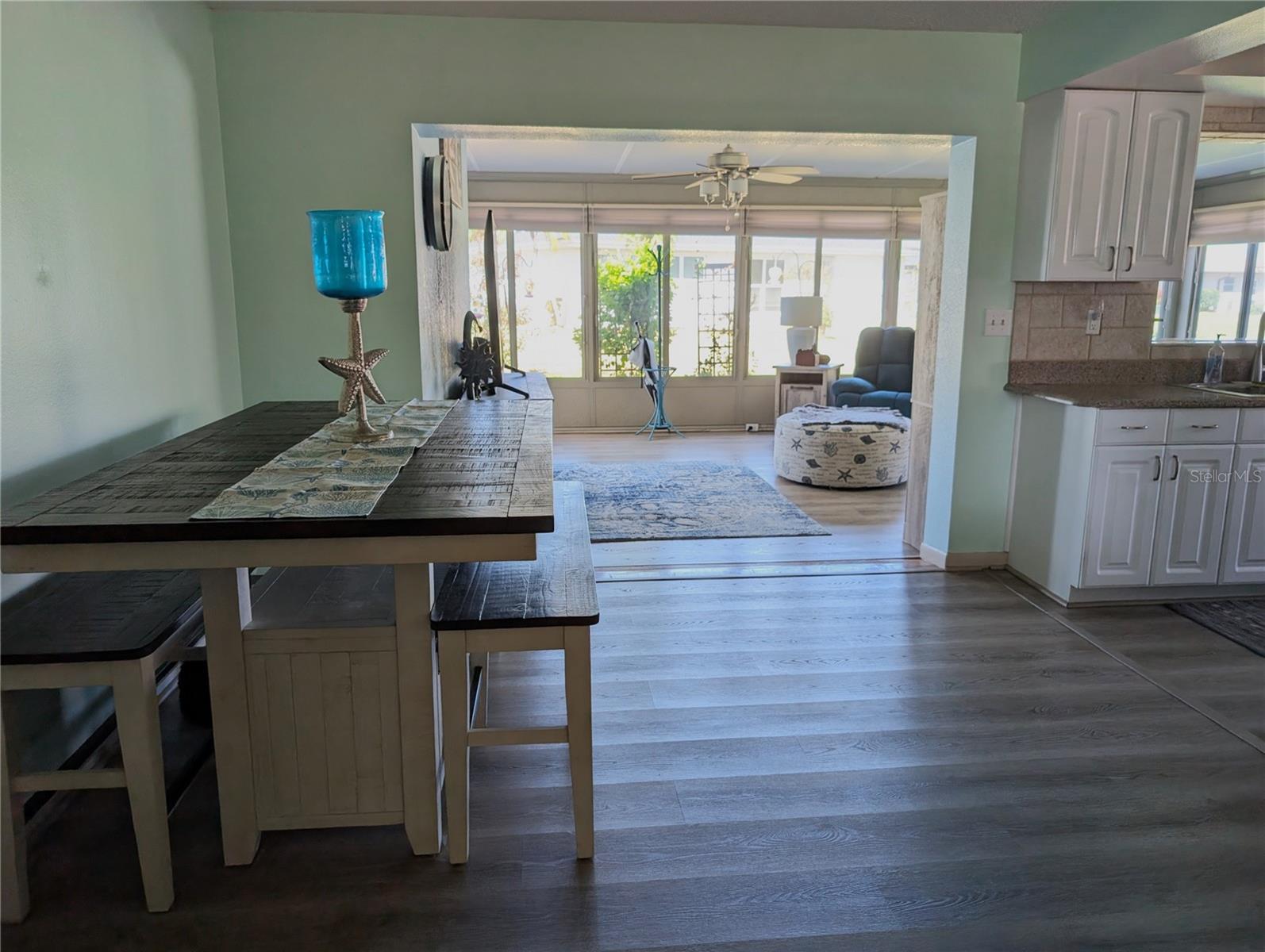 View of dining area into kitchen (on right) and Florida room.