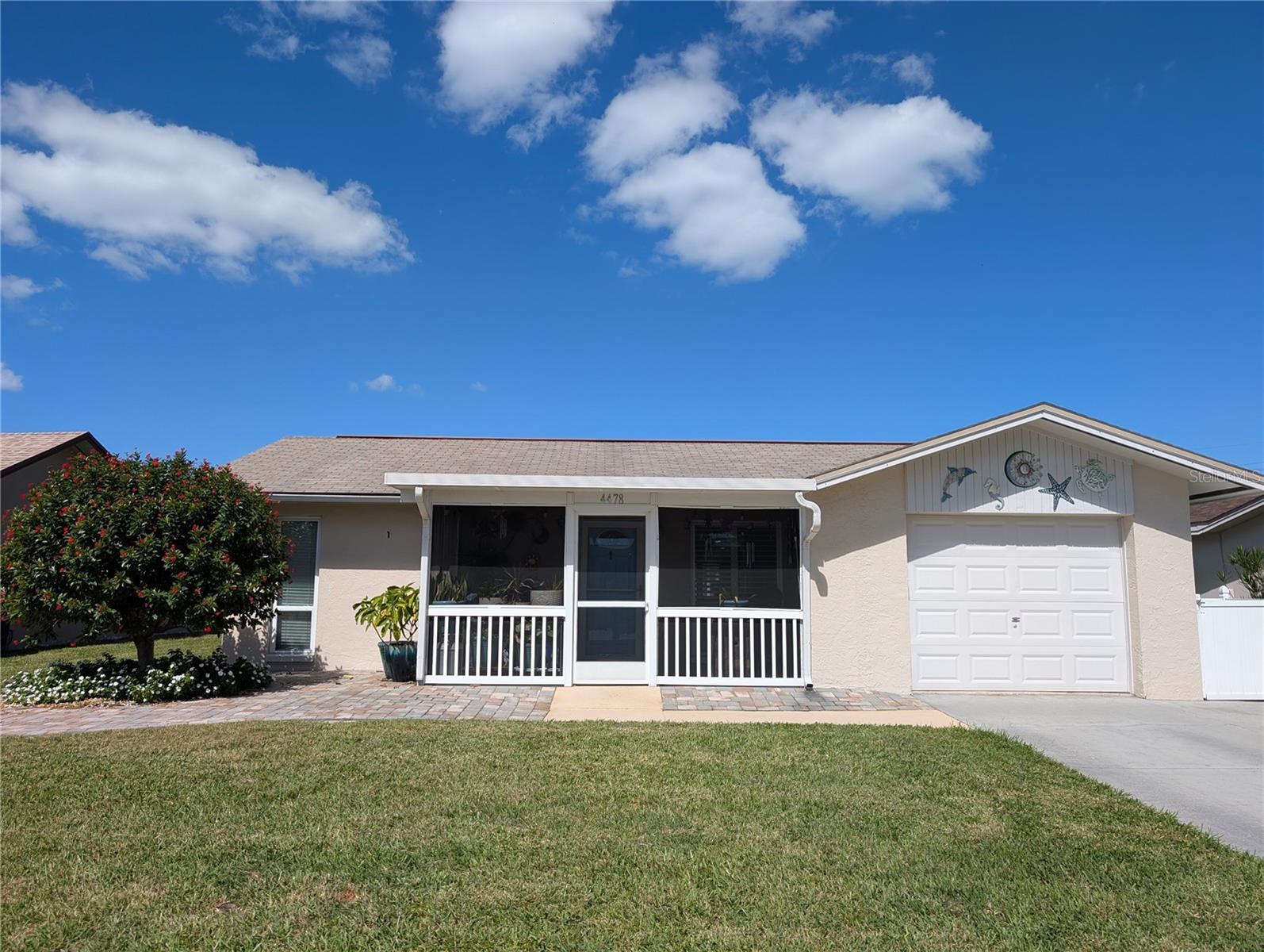 Front view of entire screened porch.  Exterior features include: pavered walkway, extended driveway to accommodate two vehicles, fresh coat of paint, shingle roof and updated windows.