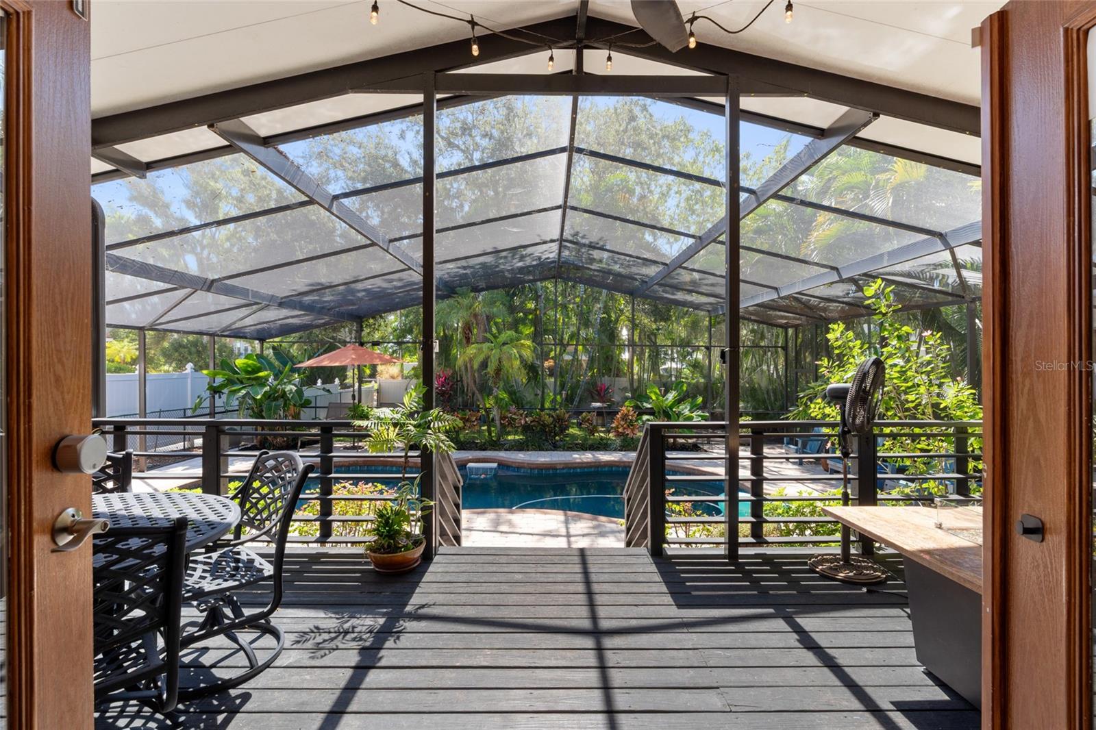 FROM THE BONUS ROOM YOU OPEN THE DOORS WIDE AND TAKE IN THE BEAUTY OF THE TROPICAL TRANQUIL BACKYARD AND POOL.