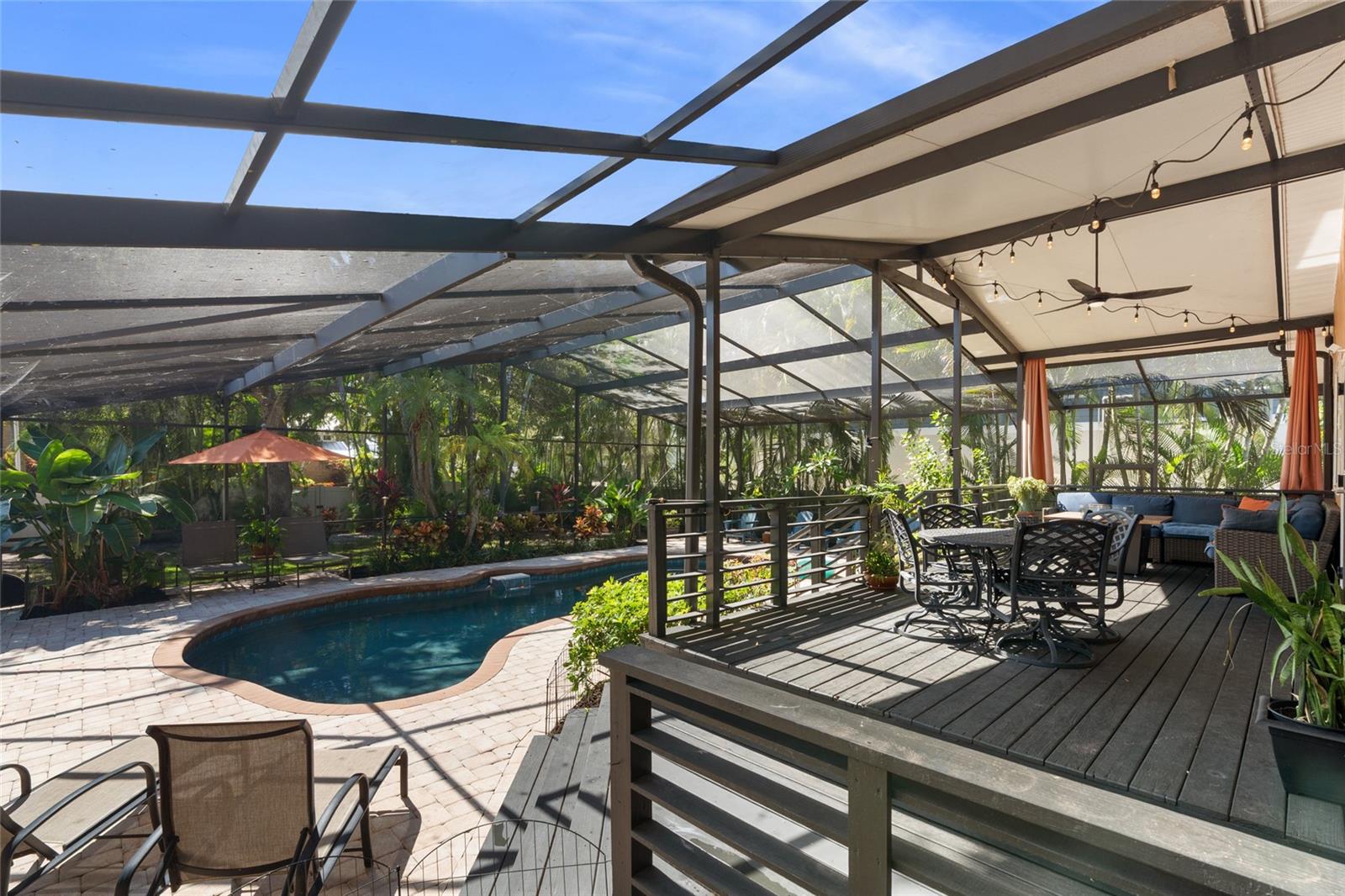FULLY SCREENED IN POOL WITH LUSH TROPICAL LANDSCAPING