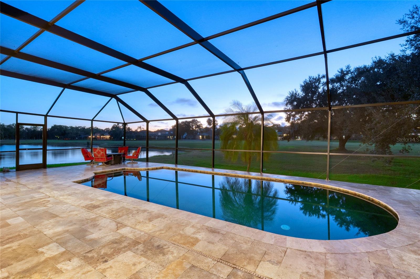 Gorgeous pool with screen enclosure and travertine pavers