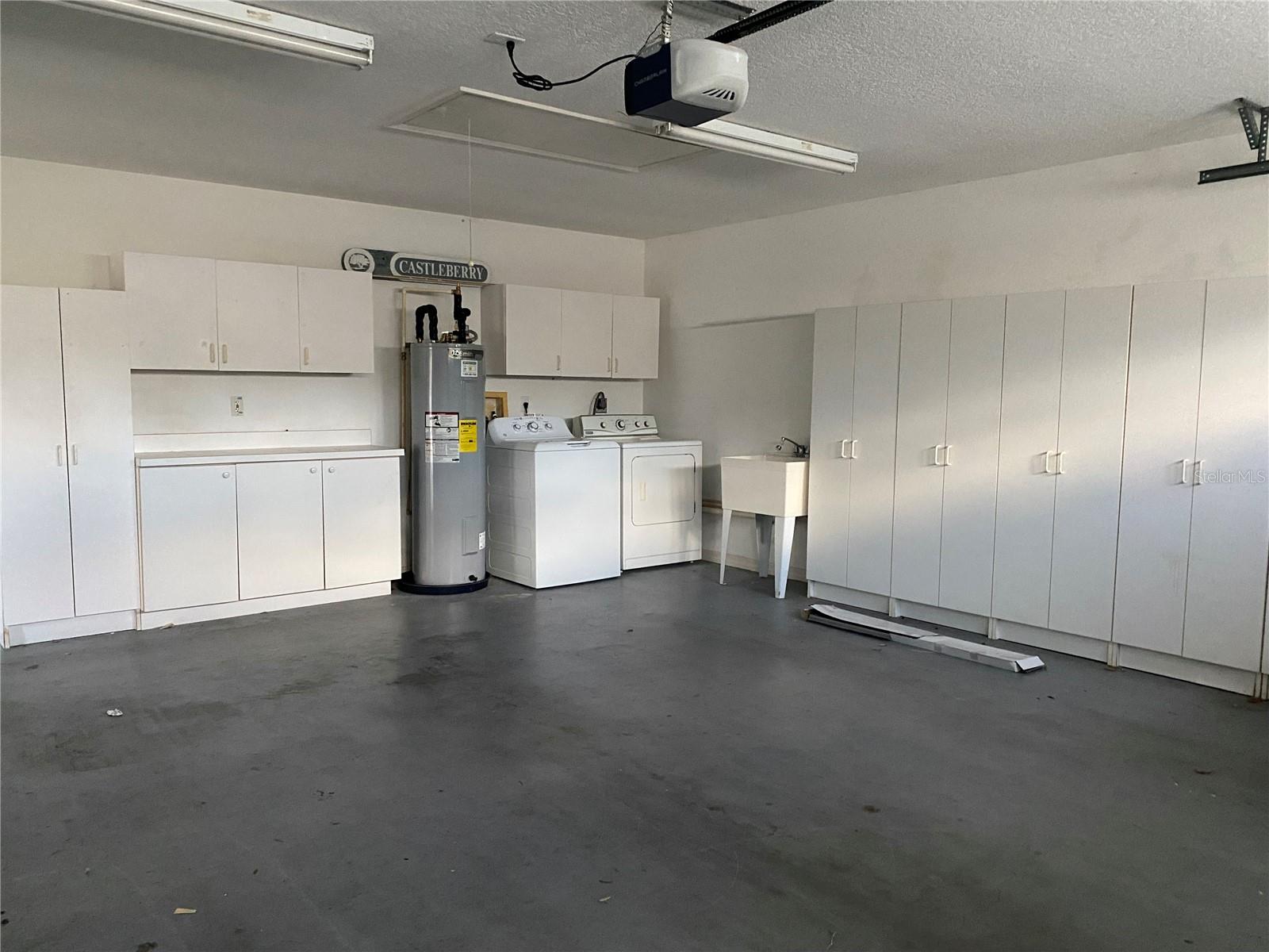 Garage with storage cabinets, wash tub, washer/dryer