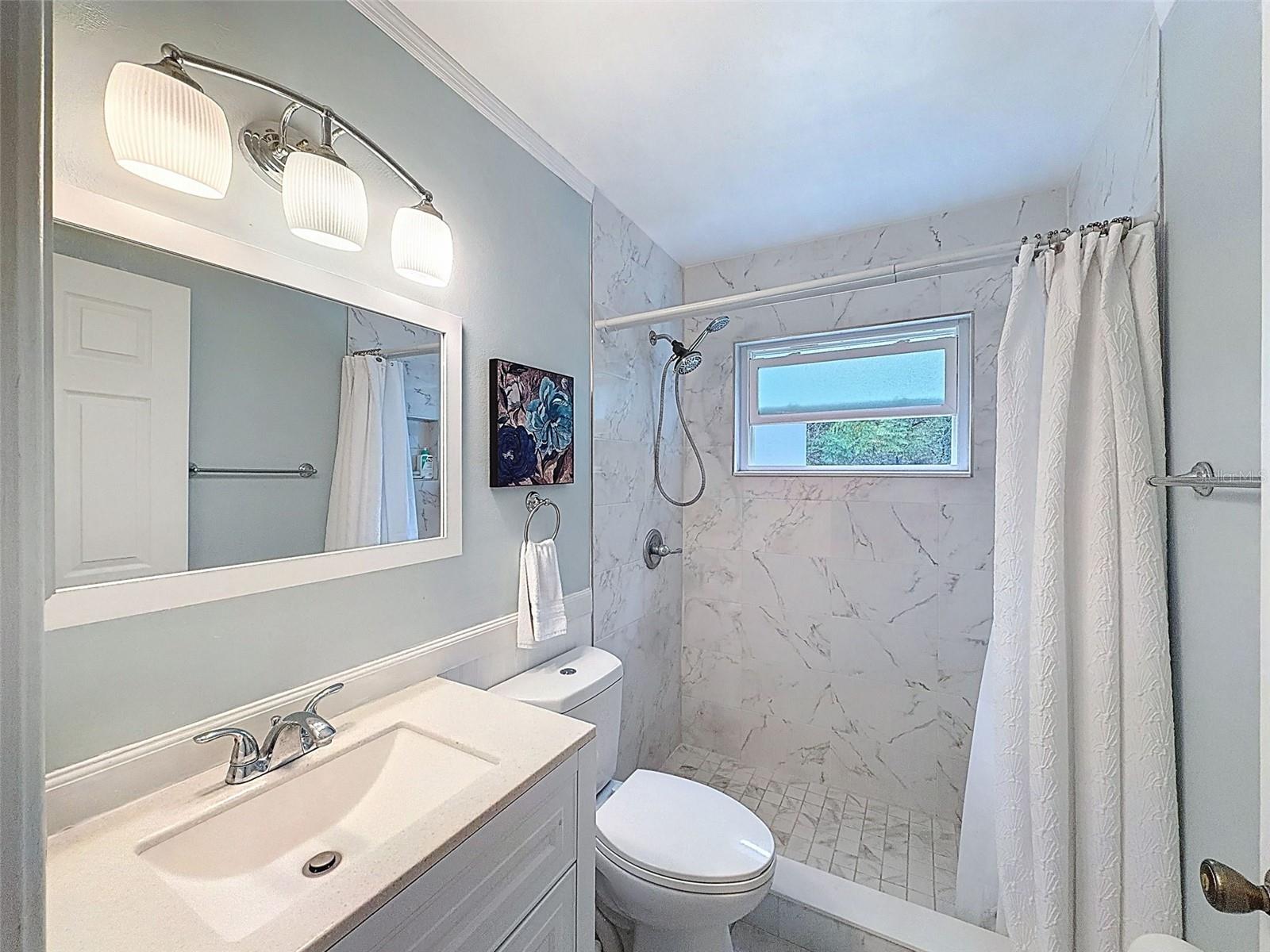 Second hallway bathroom is so clean and modern with a window for fresh air and light.