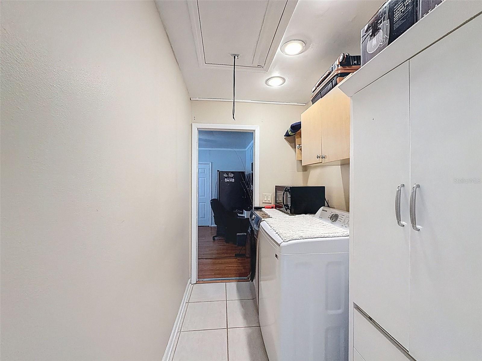 Laundry room leading to garage partially converted into a flex room.