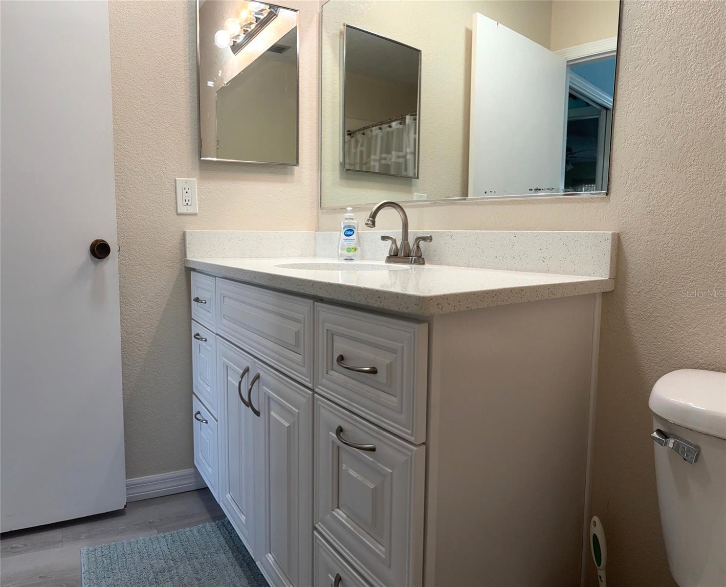 Primary Bathroom easy glide cabinets and corian counter tops