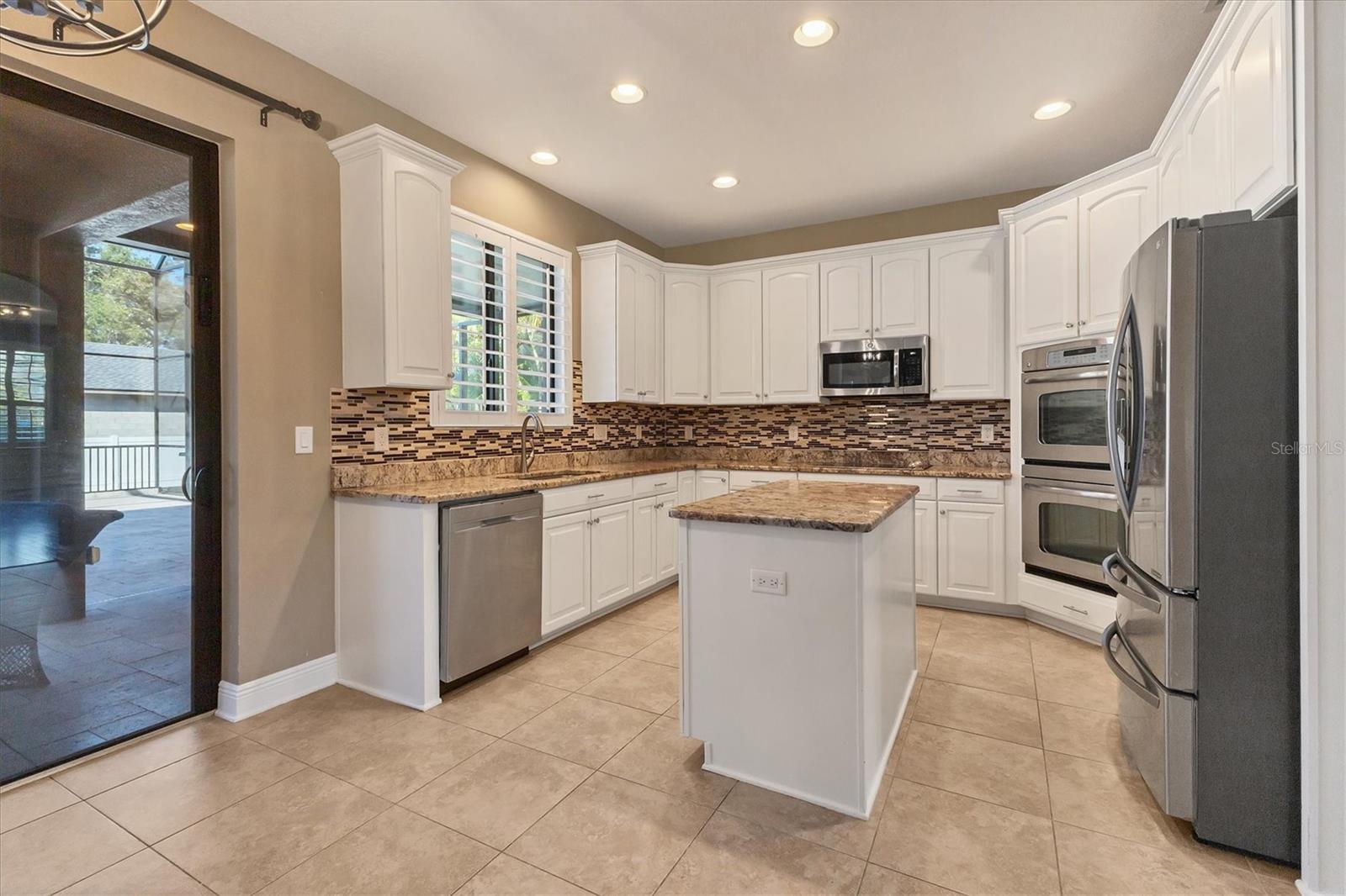 Well-appointed kitchen offers granite countertops, 42" upper cabinets, lower cabinets some of which have pull out shelf, a glass cooktop, S/S dishwasher, microwave, dual wall ovens and French Door refrigerator.