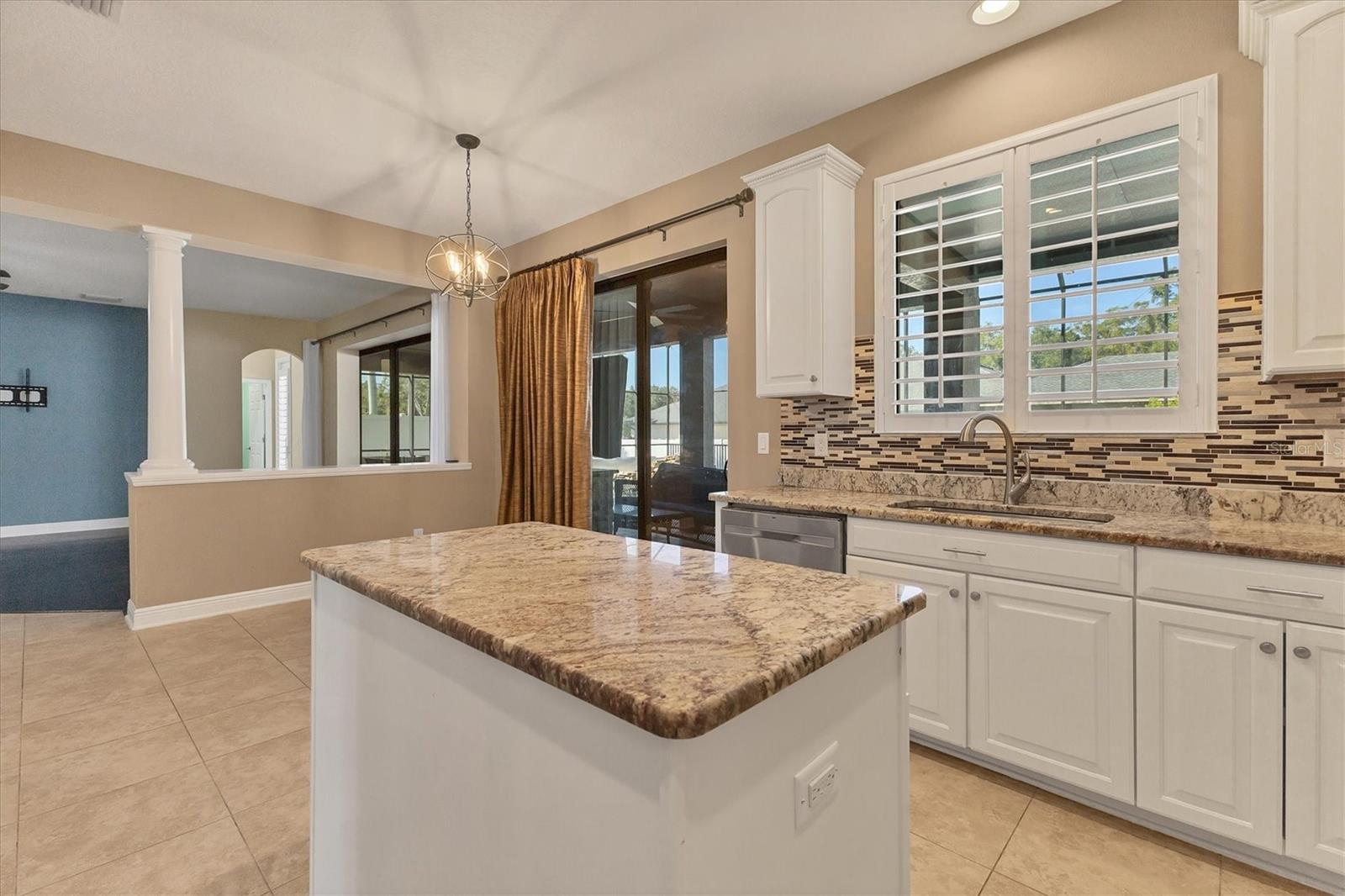 Handy food prep island with storage cabinets.  Sliders lead to pool & patio making entertaining a breeze!