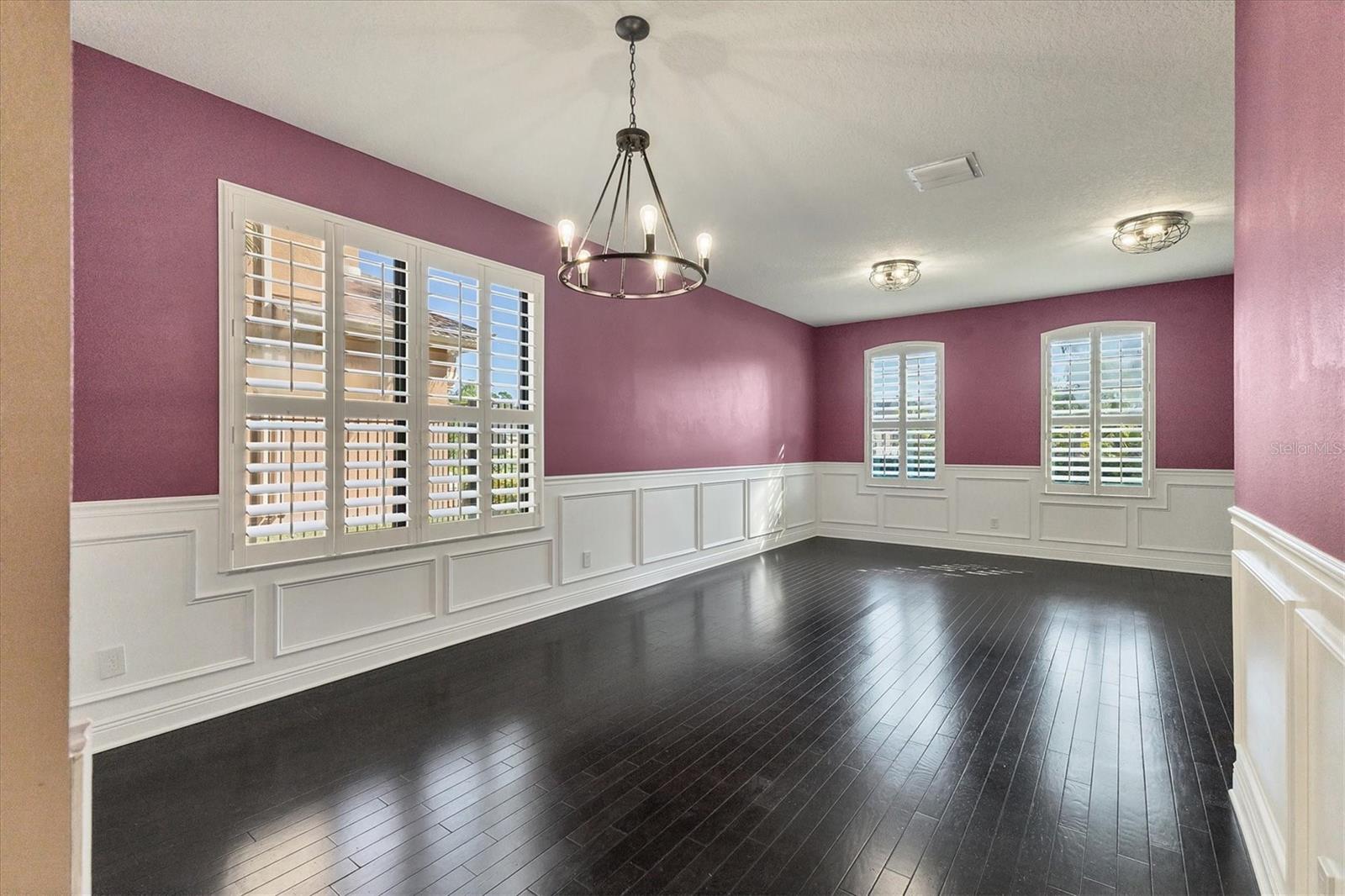 Elegant formal dining and living areas feature wainscotting, wood floors and Plantation shutters.