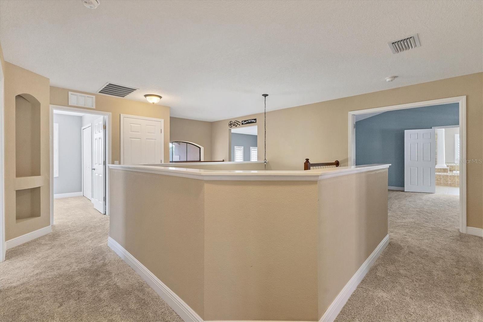 Upstairs hallway to bedrooms and bonus room wraps around the centrally located staircase