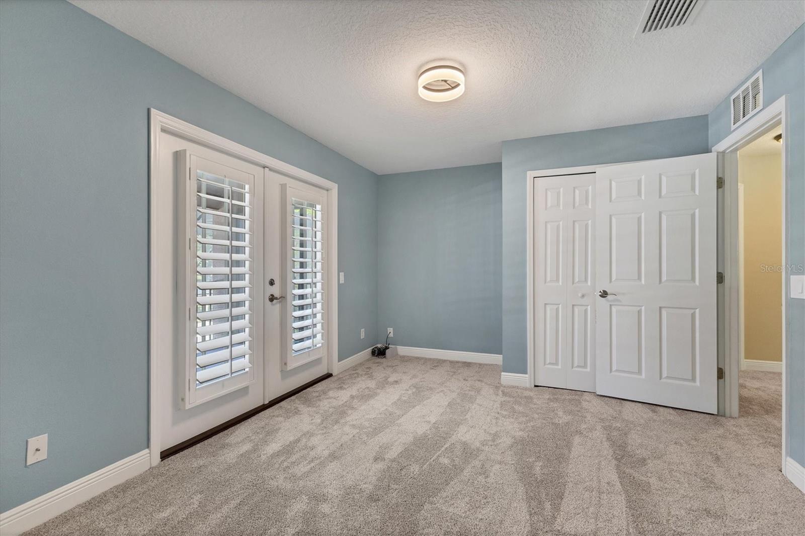 Adjoining bedroom off the primary suite has a built-in closet and a door to main hallway