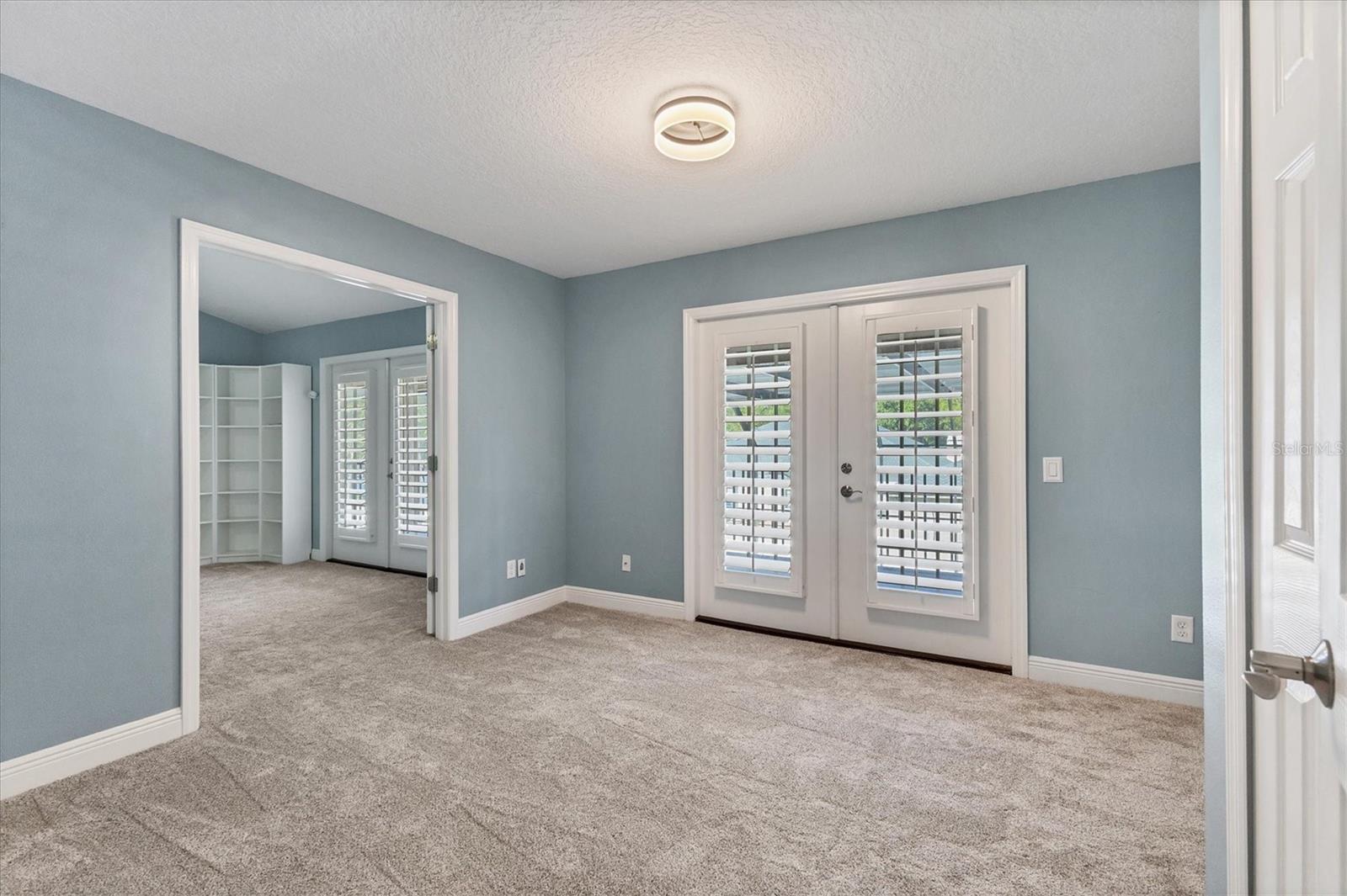 French doors lead outside to the upstairs deck