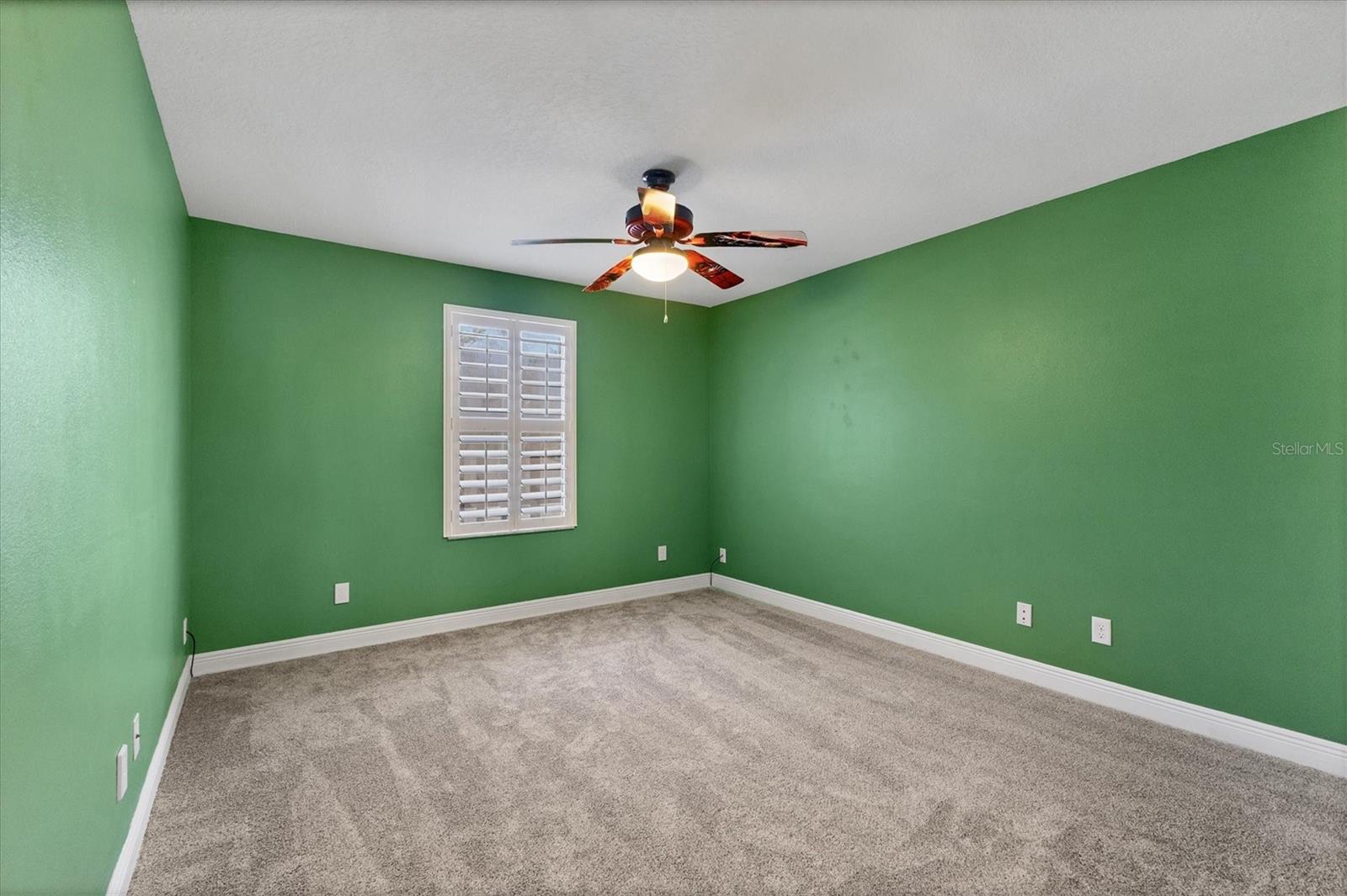 Back bedroom located on opposite side of house from the primary bedroom also overlooks pool/patio