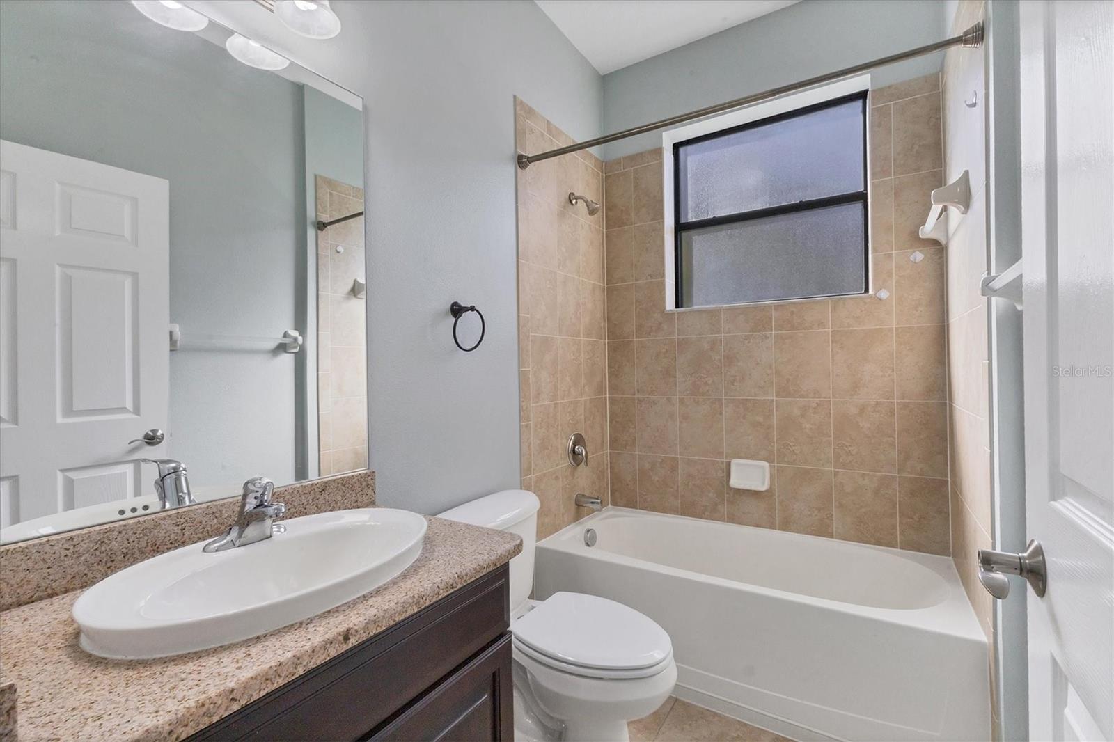 Downstairs full bathroom with granite countertop and tub/shower combo
