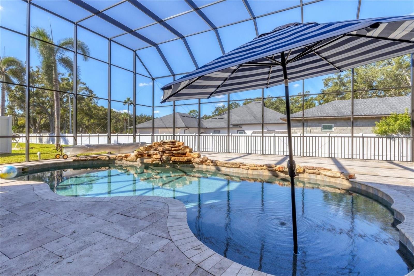 Refreshing pool has a rock waterfall feature.  Solar blanket on handy cart with reel is included
