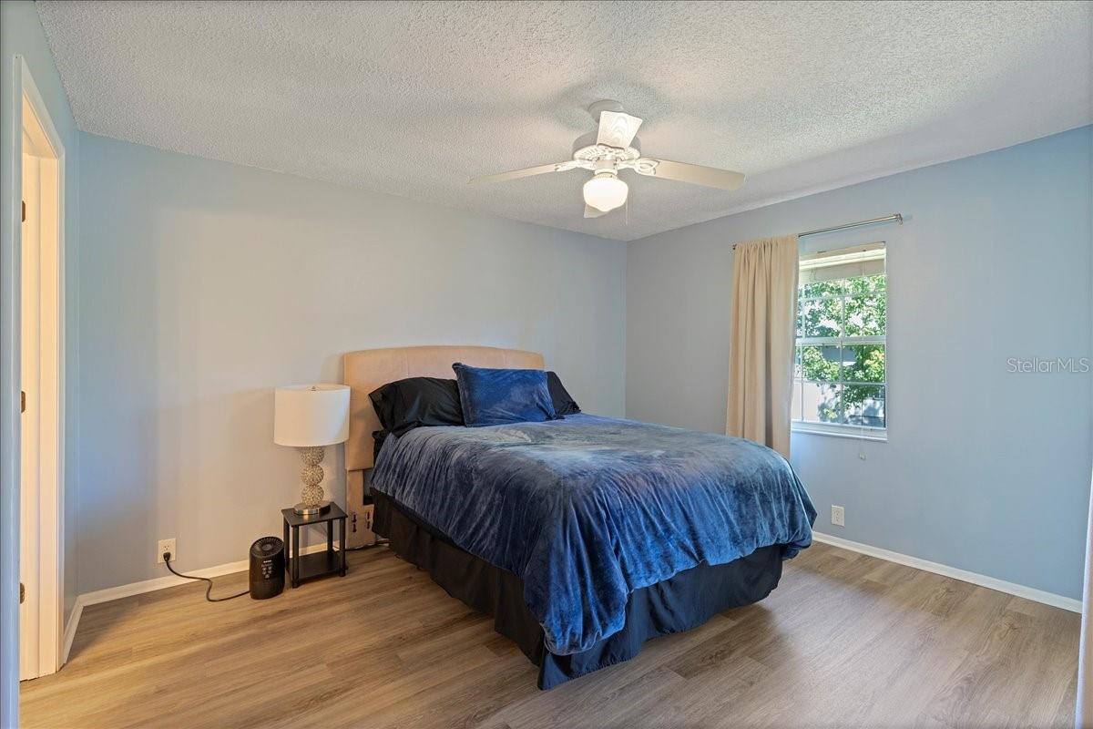 Primary bedroom with glass sliders to balcony, ensuite bathroom and walk-in closet