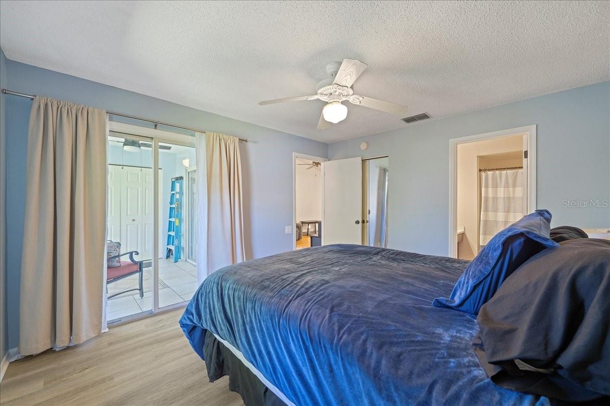 Primary Bedroom with glass sliders to balcony, ensuite bathroom and walk-in closet