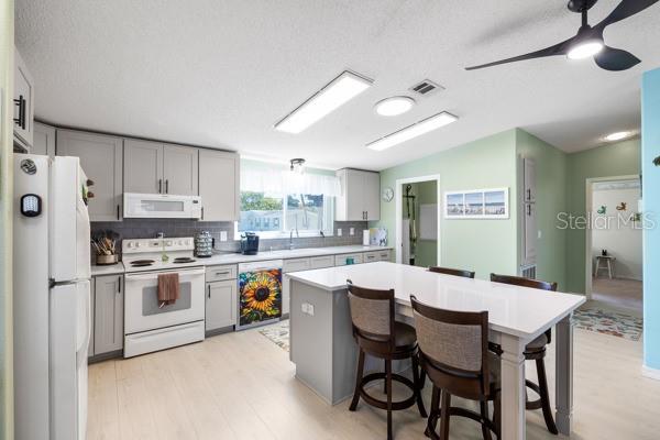 Newly remodeled kitchen with stunning Quartz countertops, wood cabinets, new light fixtures and flooring