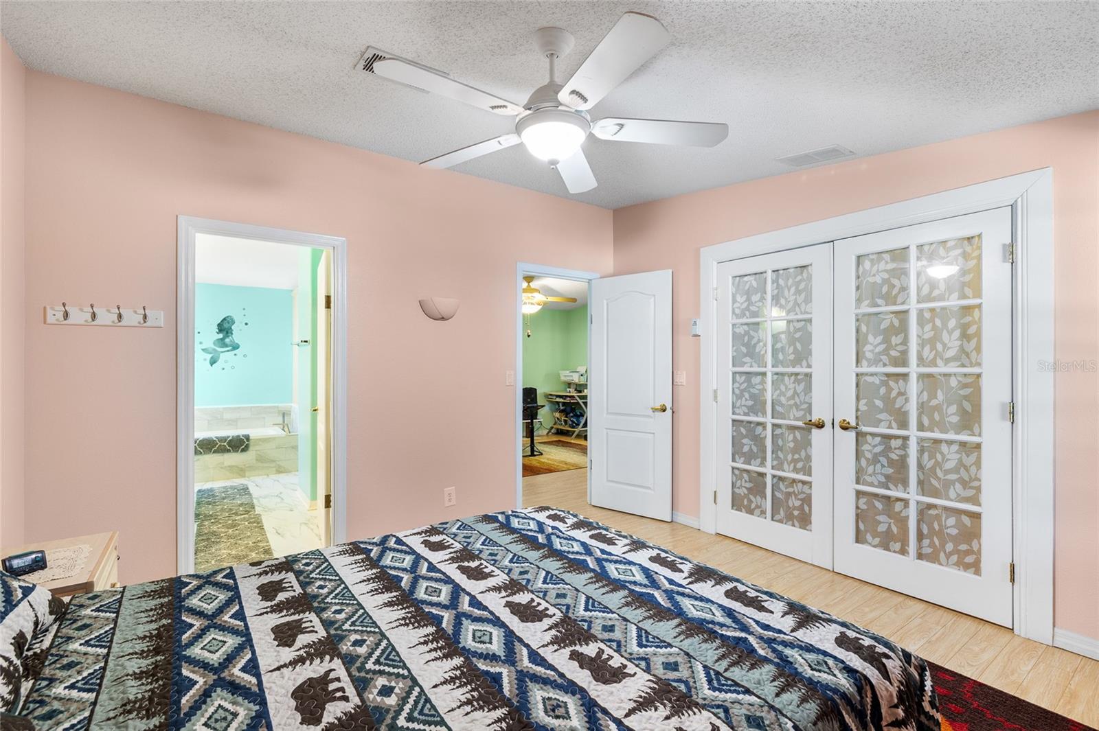 Primary Bedroom offers French doors with a walk-in closet, ceiling fan, plenty of room for a King Bed, ensuite bathroom with garden tub, step-in shower, dual sink
