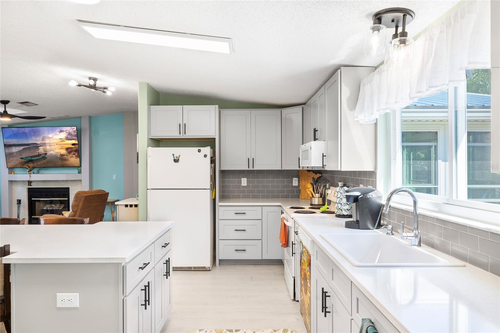 Newly remodeled kitchen with stunning Quartz countertops, wood cabinets, new light fixtures and flooring