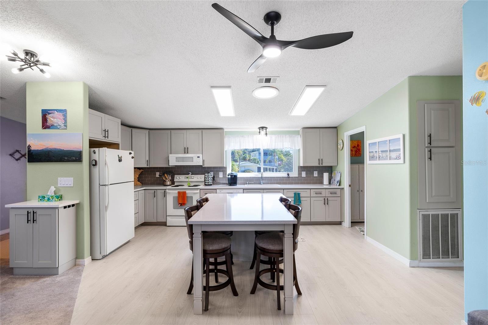 You'll want to entertain in this gorgeous newly remodled kitchen boasting Quartz countertops, center island, new light fixtures and plenty of natural sunlight.