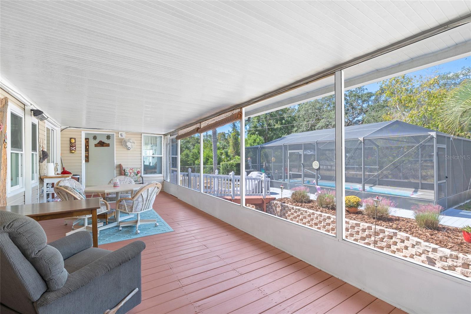 Screened patio overlooking the lovely garden and salt water pool