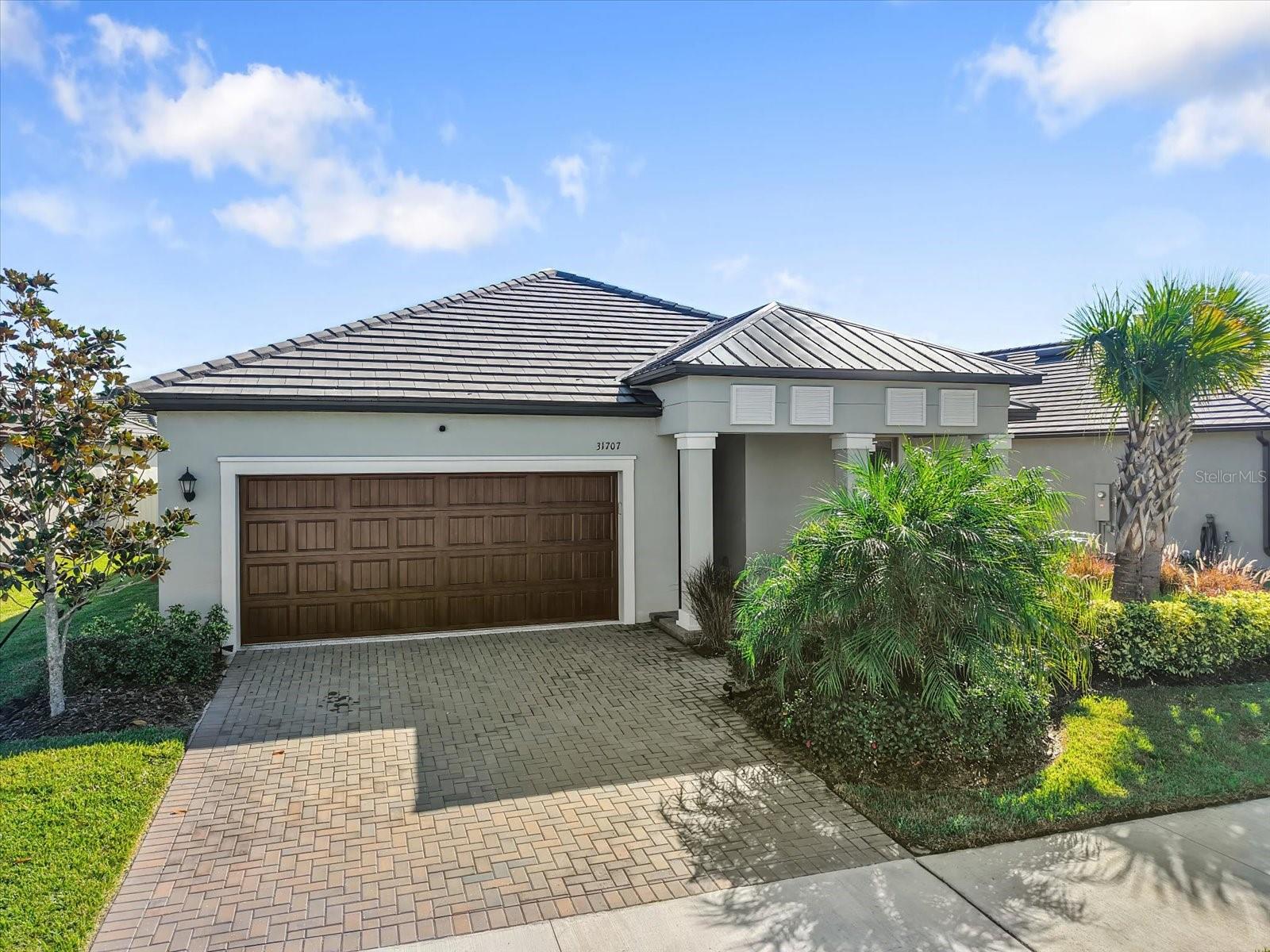 Pavered drive and tile/ metal roof, mature landscaping