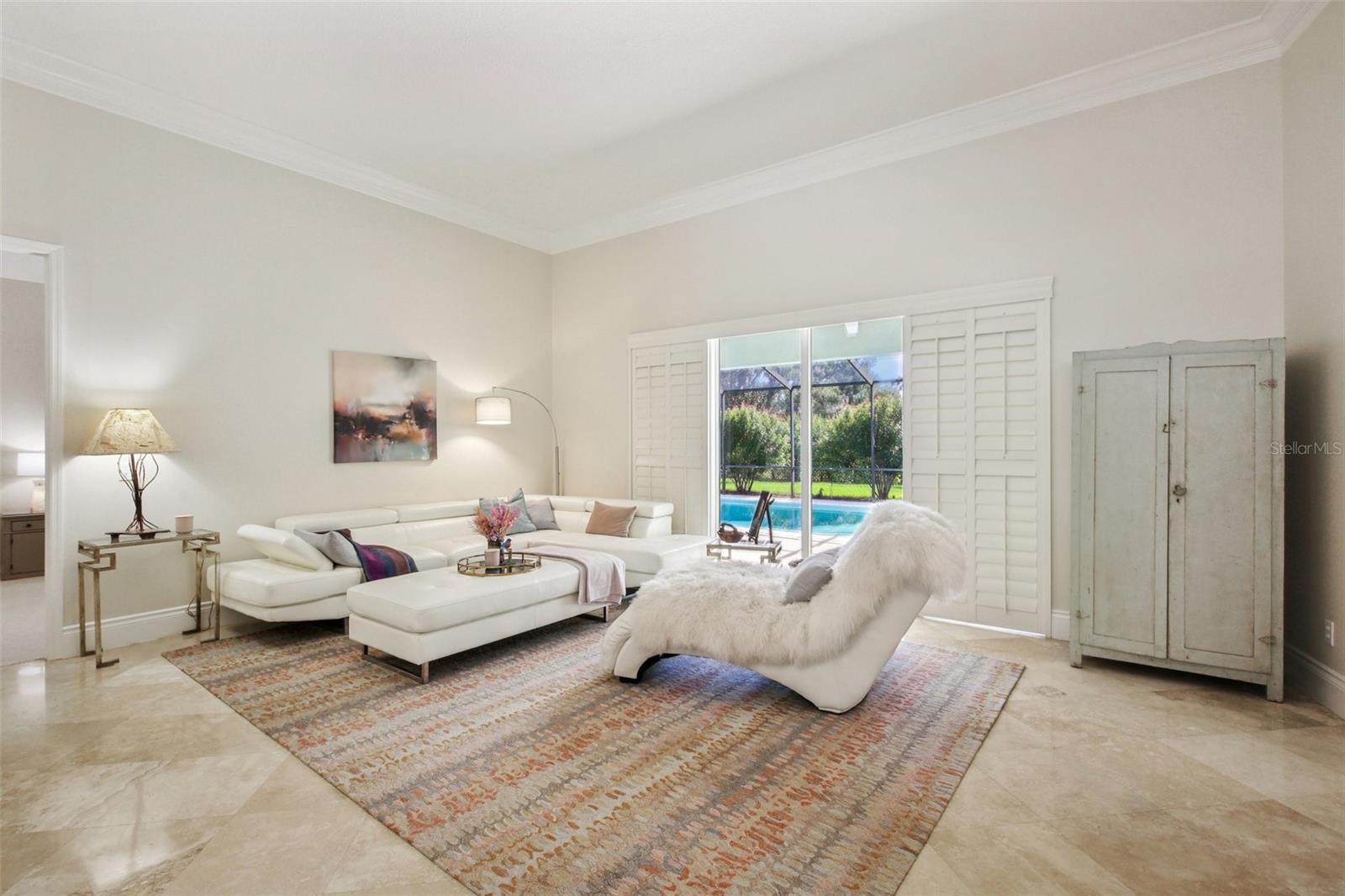 OPEN AND BRIGHT LIVING ROOM. SHUTTERED SLIDERS PROVIDE ADDITIONAL PRIVACY AS NEEDED