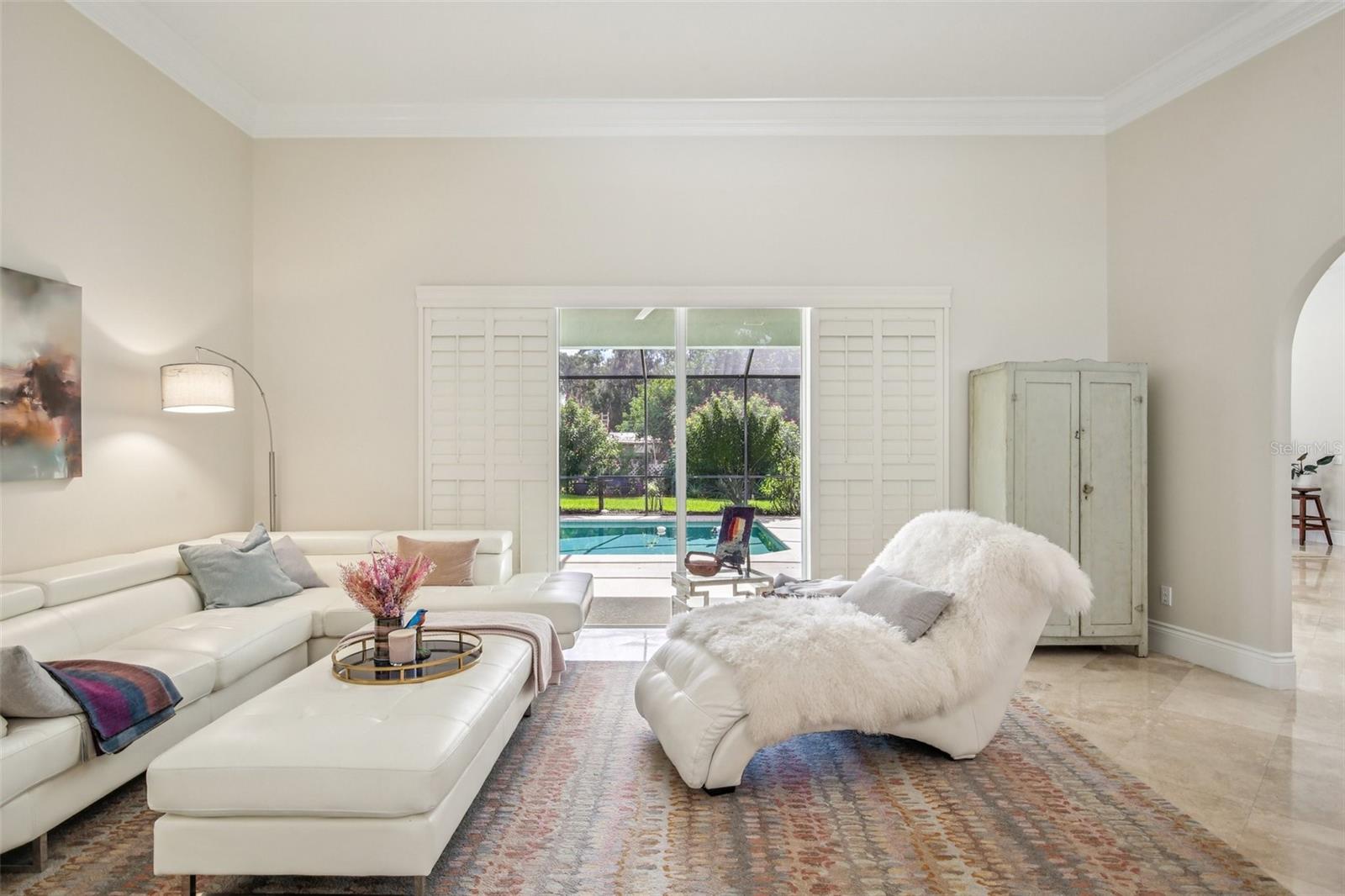 OPEN AND BRIGHT LIVING ROOM. SHUTTERED SLIDERS PROVIDE ADDITIONAL PRIVACY AS NEEDED