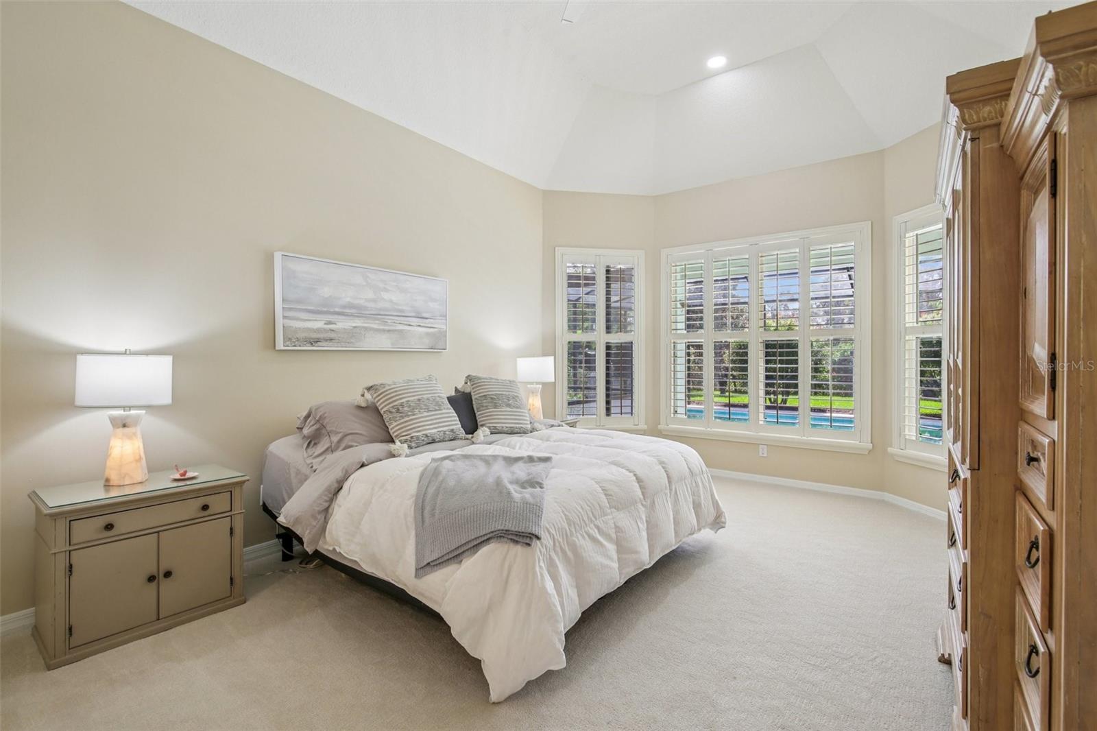 PRIMARY BEDROOM OVERLOOKS THE POOL