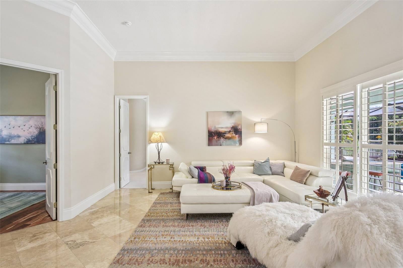 OPEN AND BRIGHT LIVING ROOM. DOORS LEAD TO PRIMARY BEDROOM AND OFFICE/BEDROOM 2