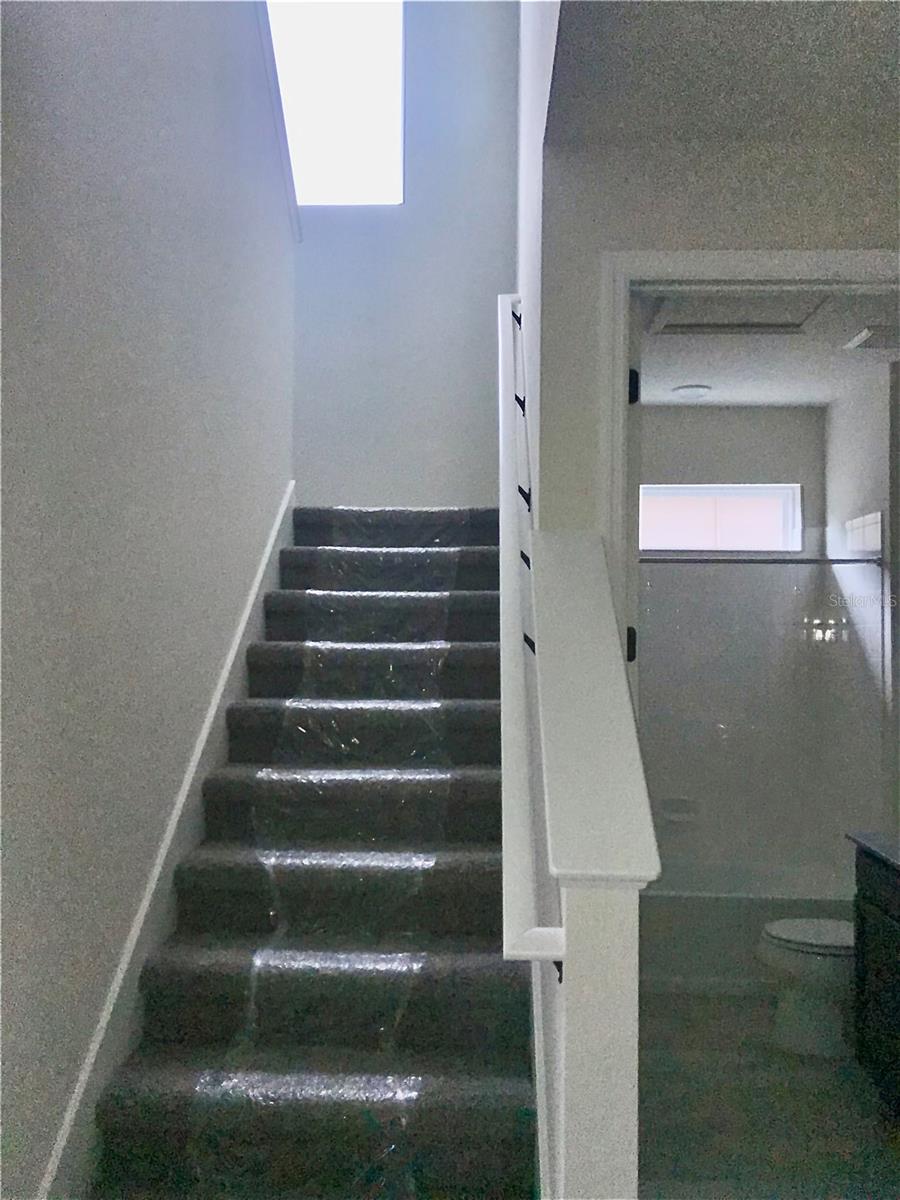Stairs to 2nd floor with view of 1st Floor guest bathroom