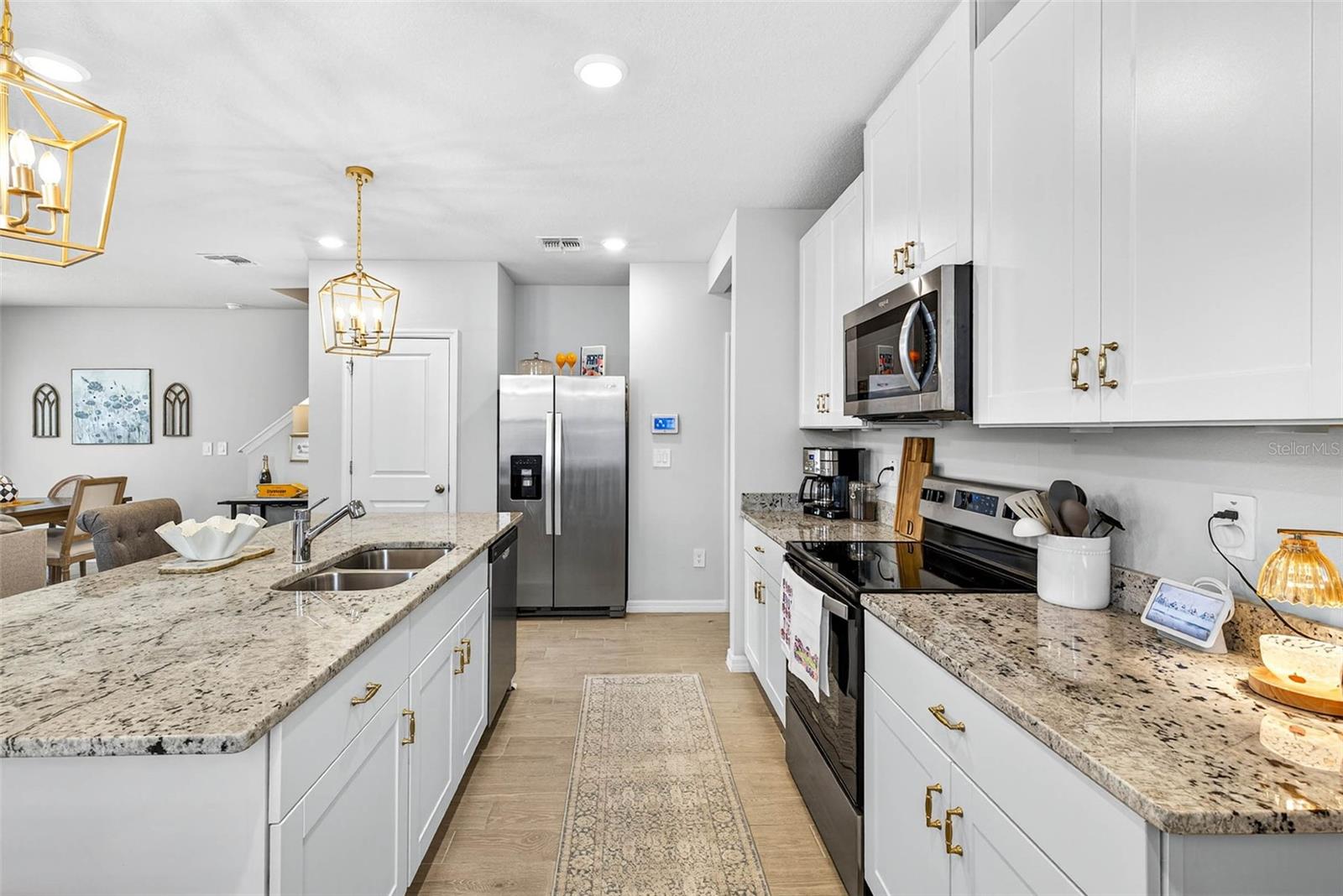 Granite countertops, white shaker cabinets, gold accents throughout pick up the color in the granite.