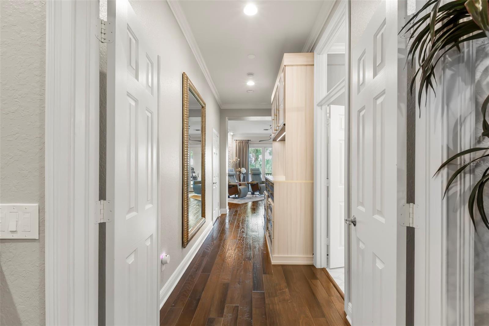 Entrance to Primary Bedroom with custom storage cabinetry in between the bathroom and closets.