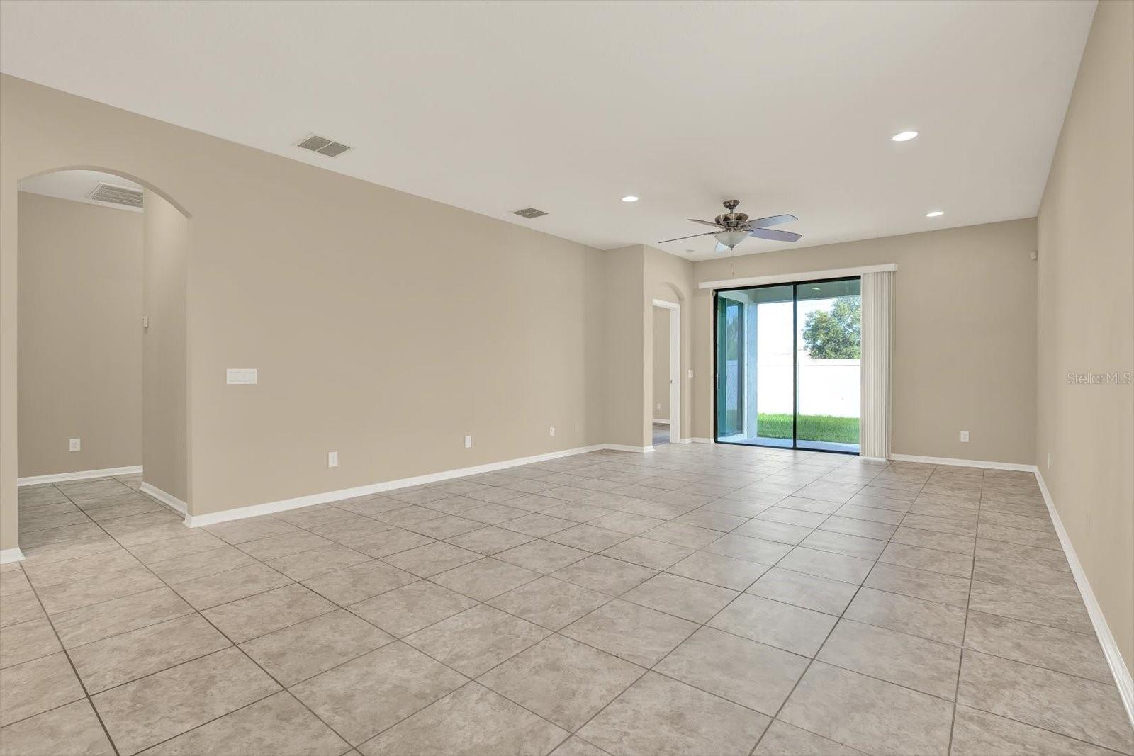 Living/Dining area with view to covered patio. View to hallway where both bedrooms, bathroom, laundry room and exit to garage are located