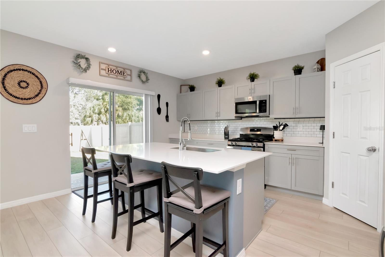 Kitchen with Sliding Glass Doors, Gas Stove, Stainless Steel Appliance Pkg, Island and Corner Pantry