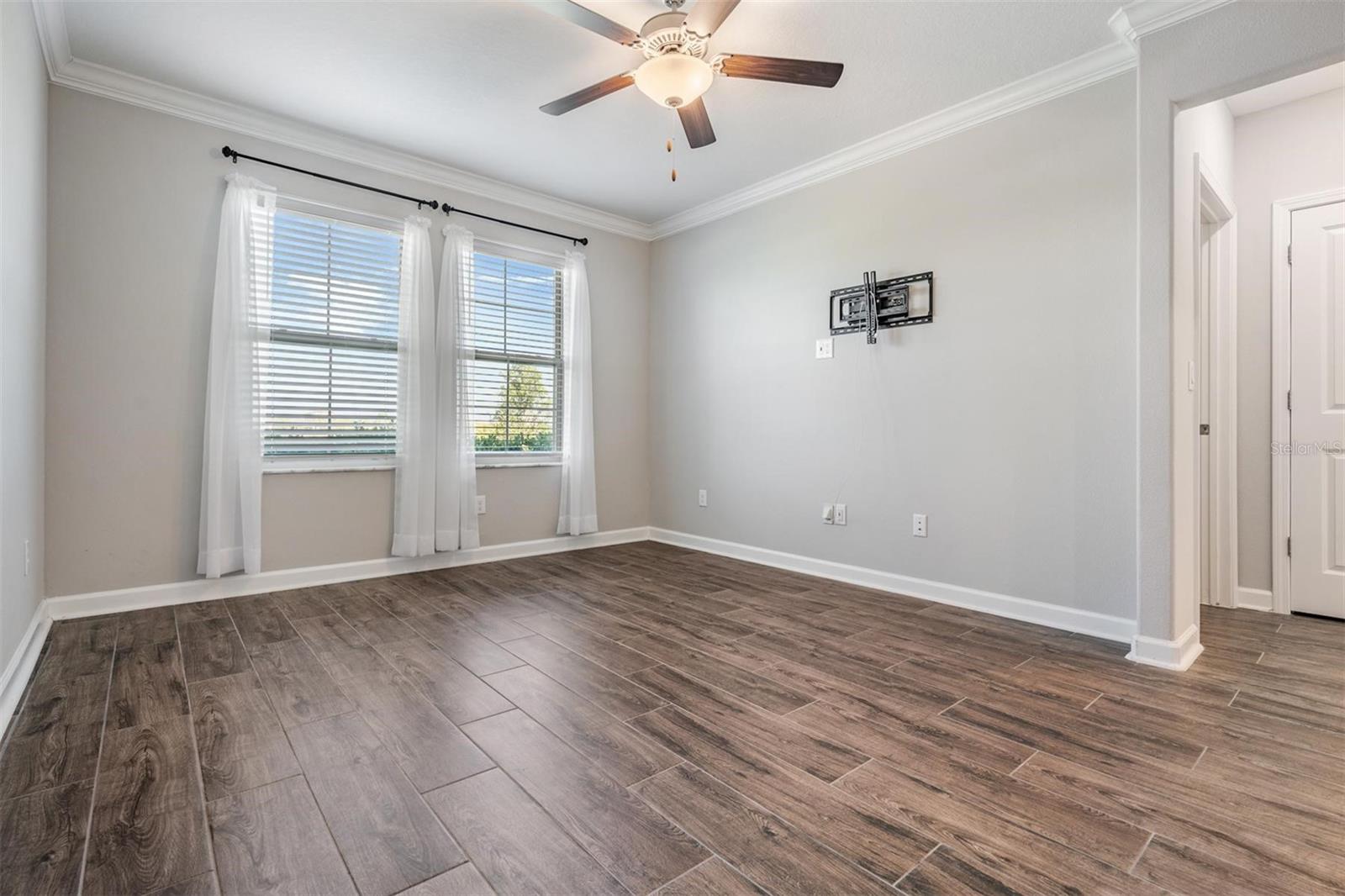 Primaray bedroom w/tile flooring, tv mount & fan