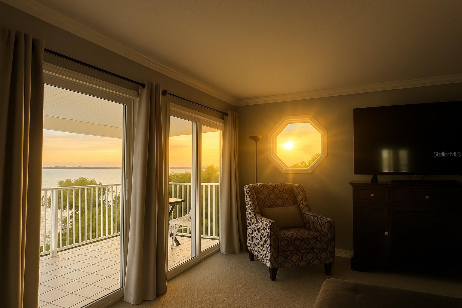 Charming porthole window adds a touch of Key West flair. Sunrise over the water in Primary Bedroom.