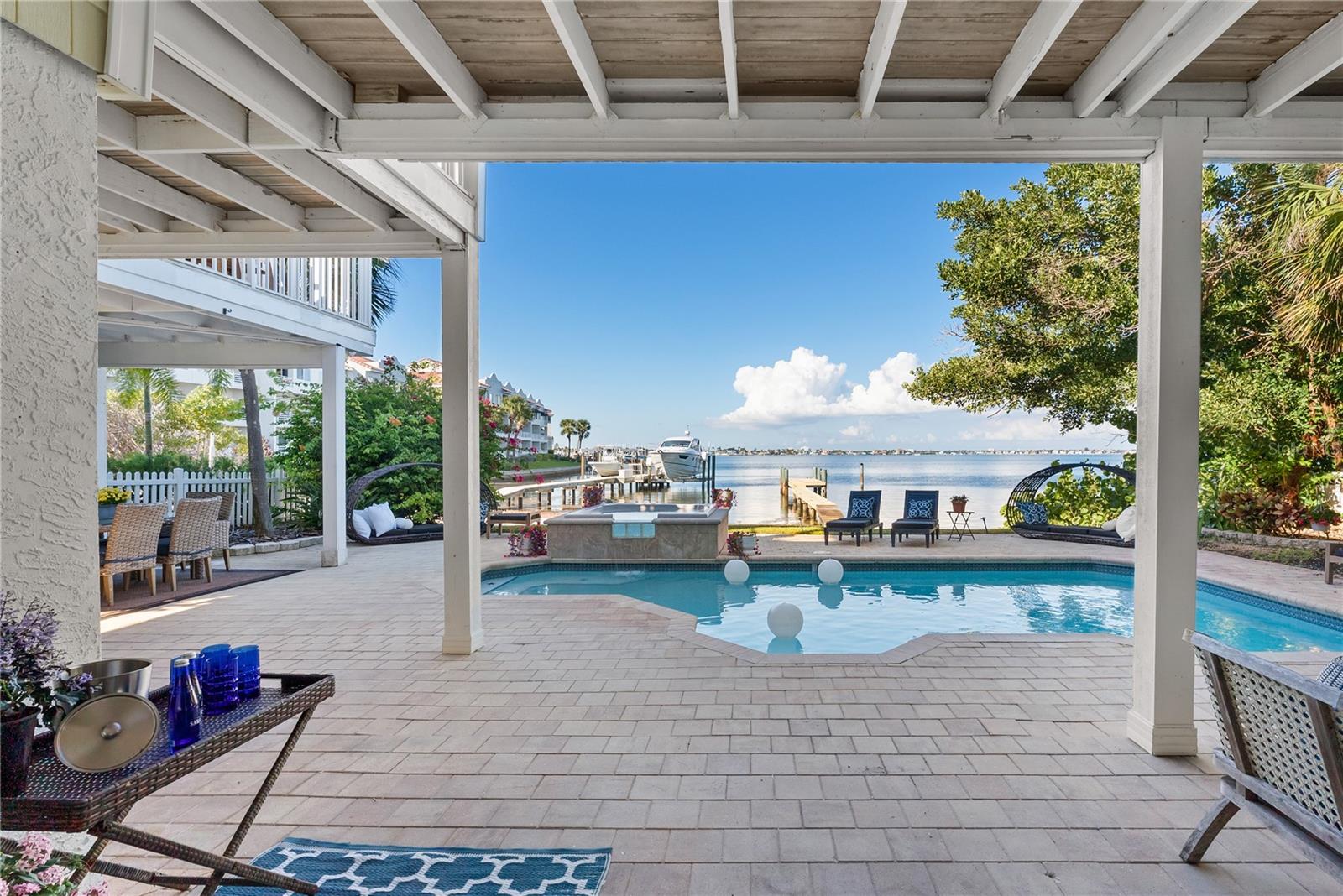 Heated pool and spa with dolphin inlay and fountain hot tub overlooking the bay