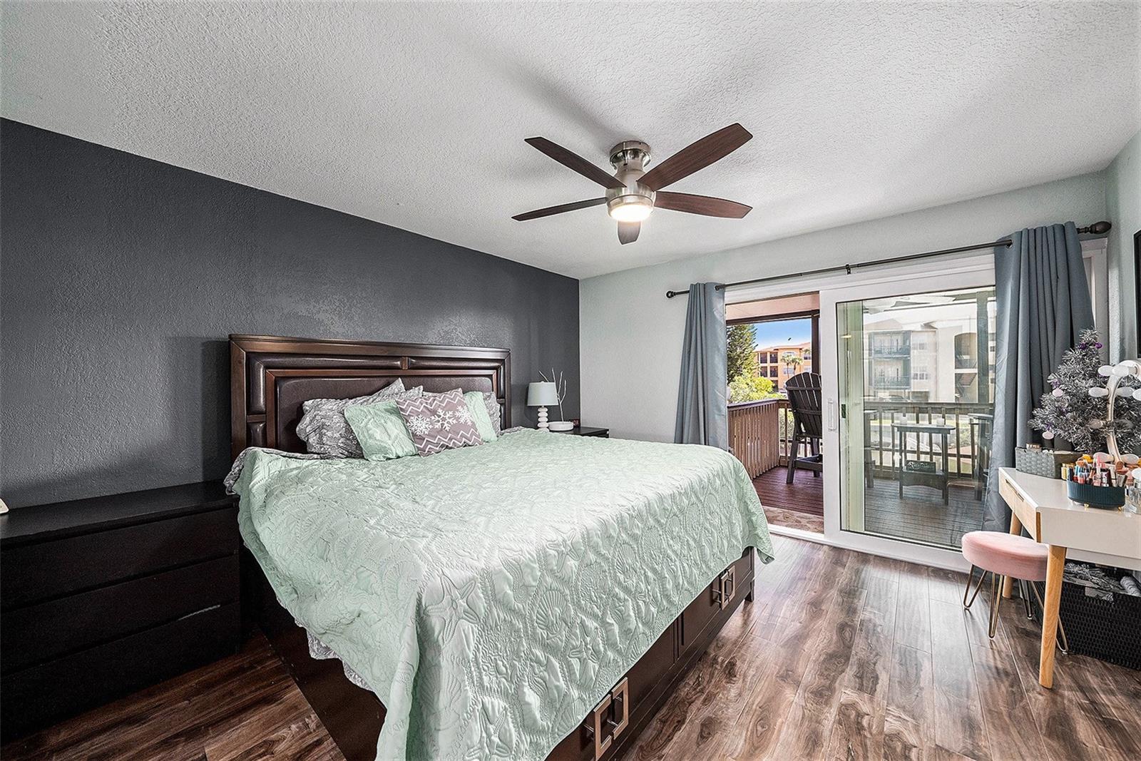 Primary bedroom with screened in balcony over looking water