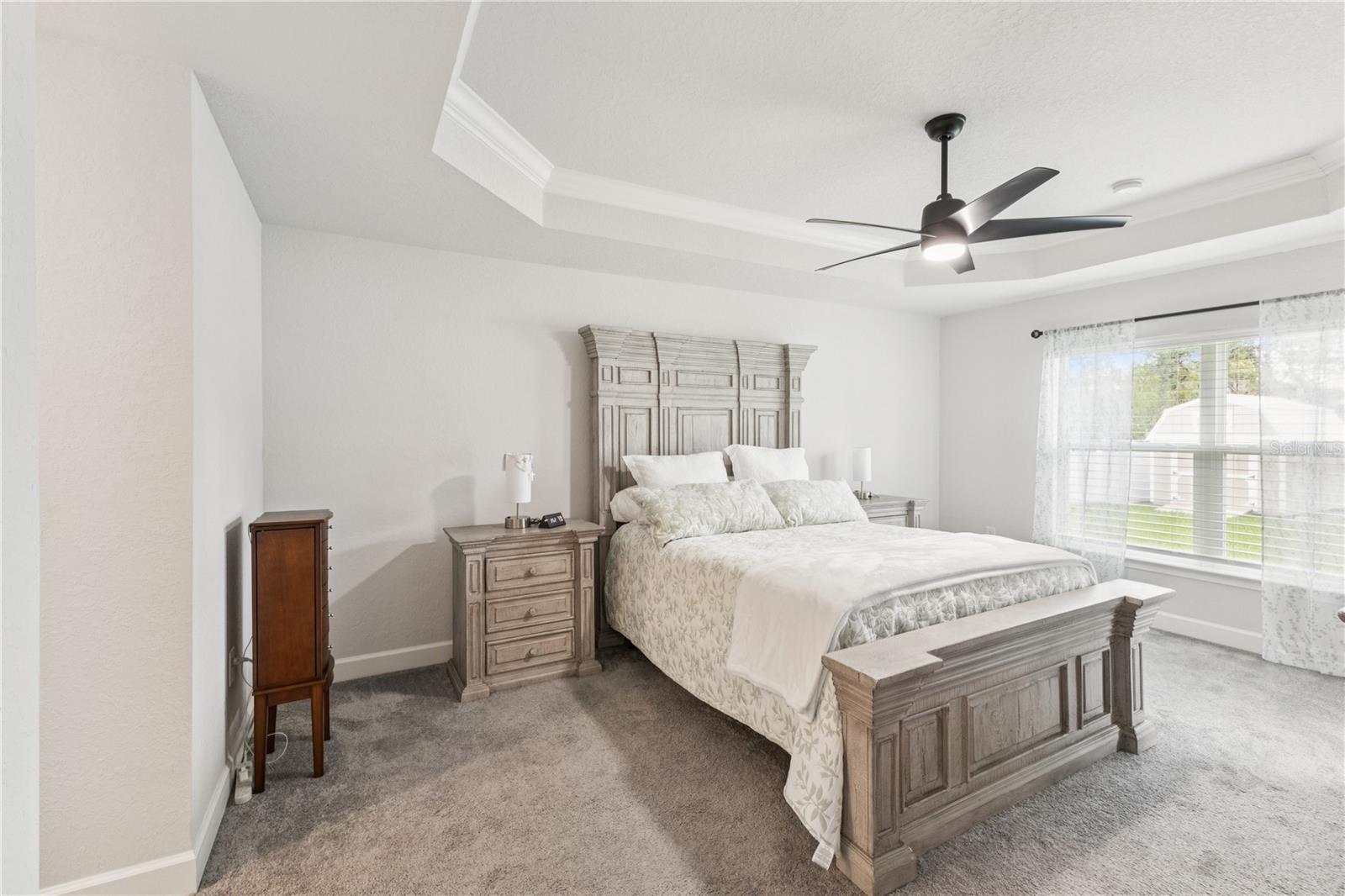 Generous size primary bedroom with tray ceilings and attached bathroom.