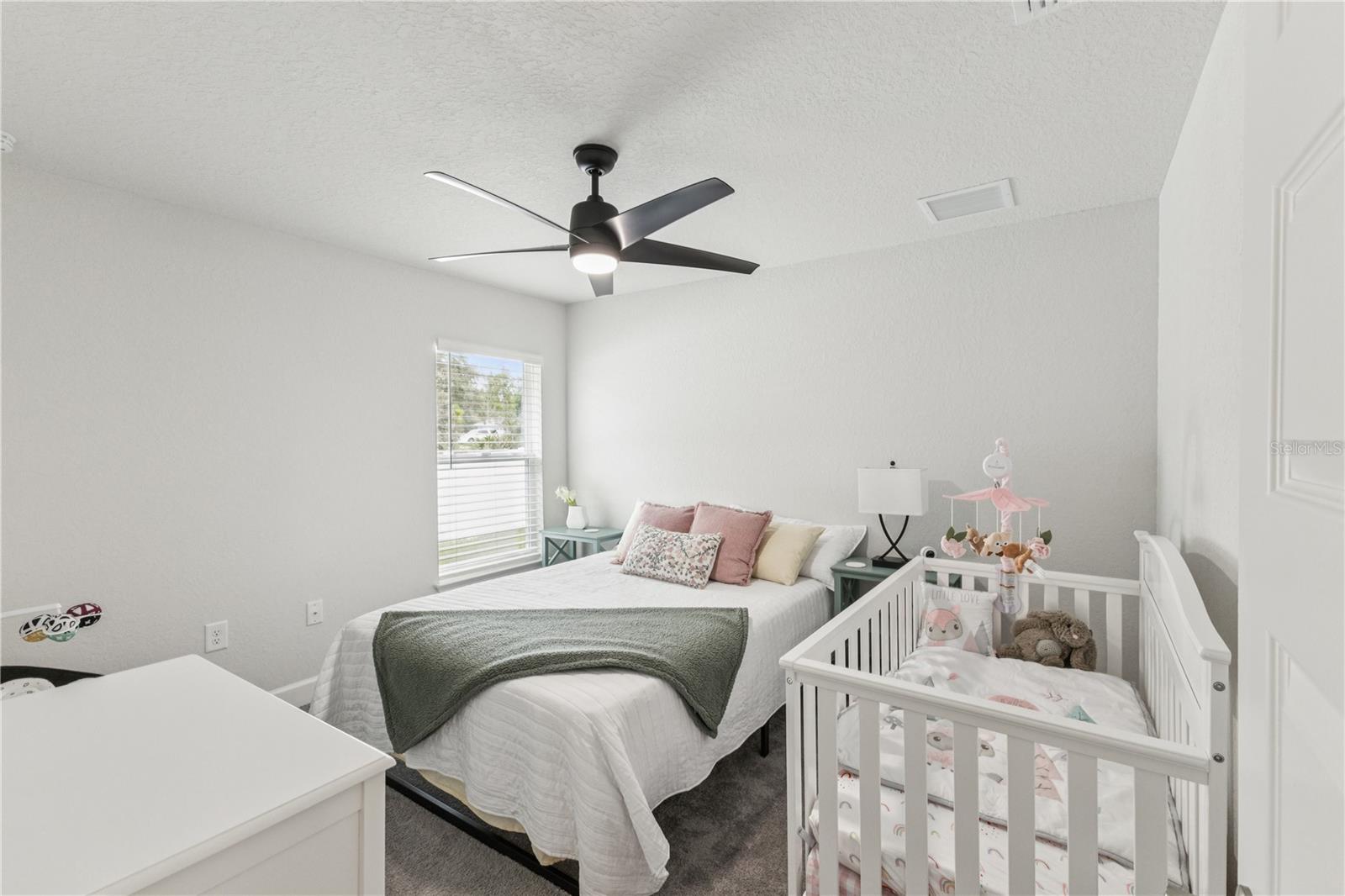 Reasonable size guest bedroom with its own unique view of the home exterior.