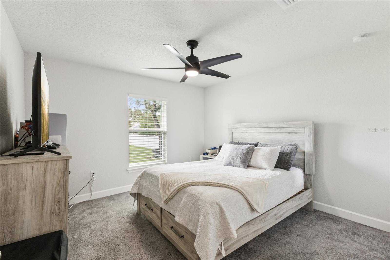 Reasonable size guest bedroom with its own unique view of the home exterior.