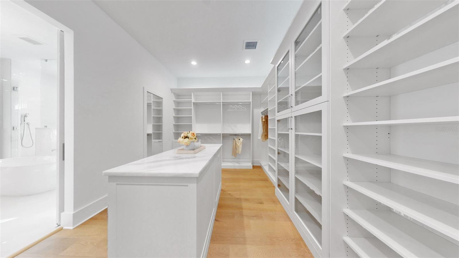 Upstairs primary walk in closet with island.