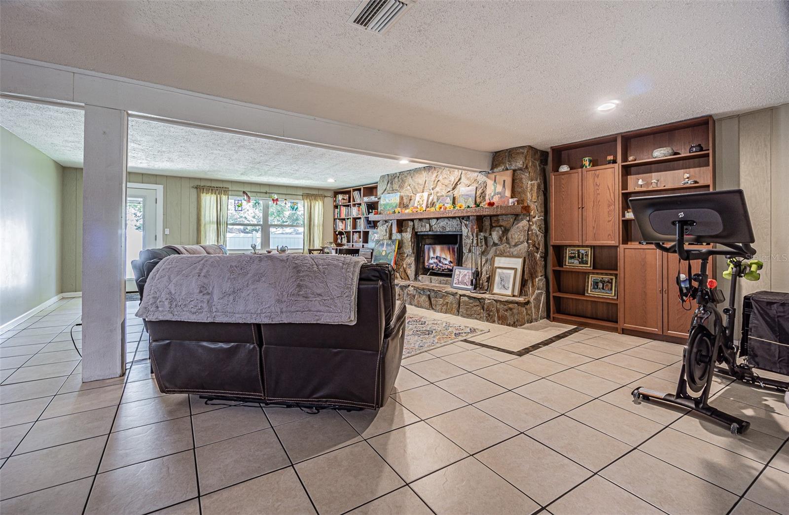 Huge family room with custom built-in shelving and a wood burning fireplace overlooking the backyard.