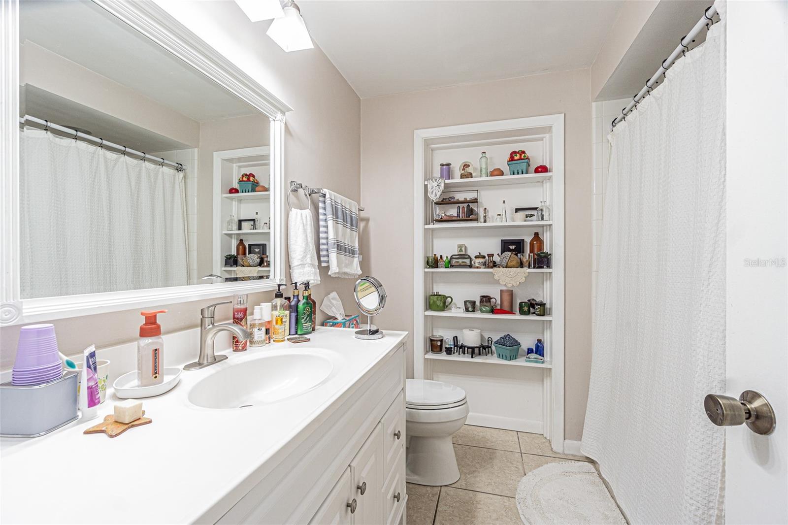 Bathroom with tub/shower and built-in custom shelving.