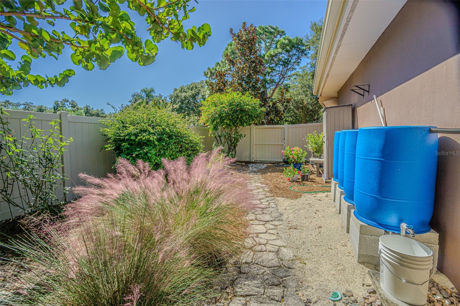 Side yard with rain barrels. The rain barrels convey as well.