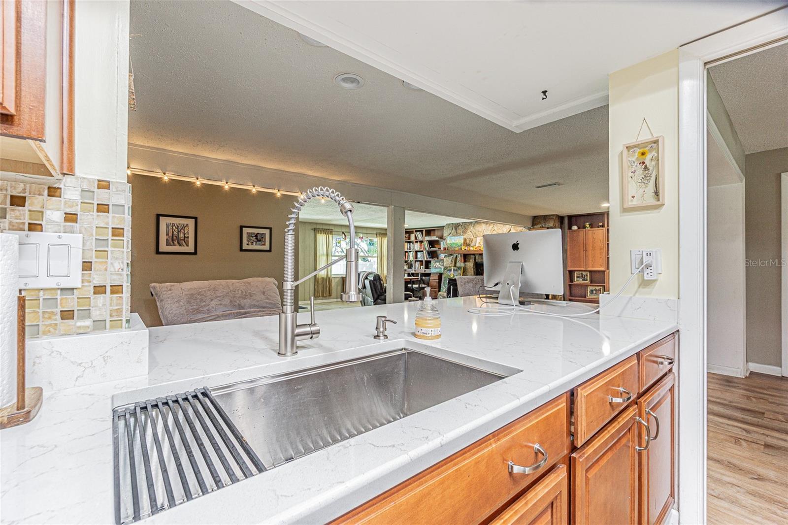 Kitchen overlooking a large flex space which could be a bonus room or playroom, and the family room to the right.