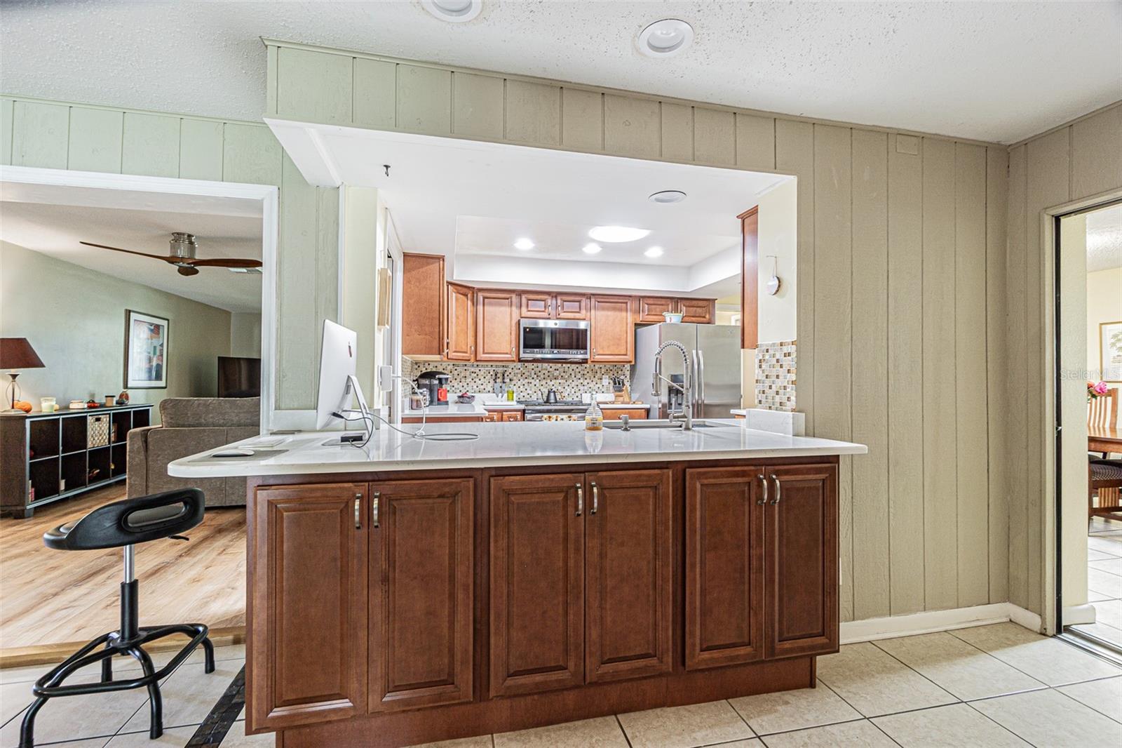 Looking into kitchen from the bonus/flex space with the living room beyond.