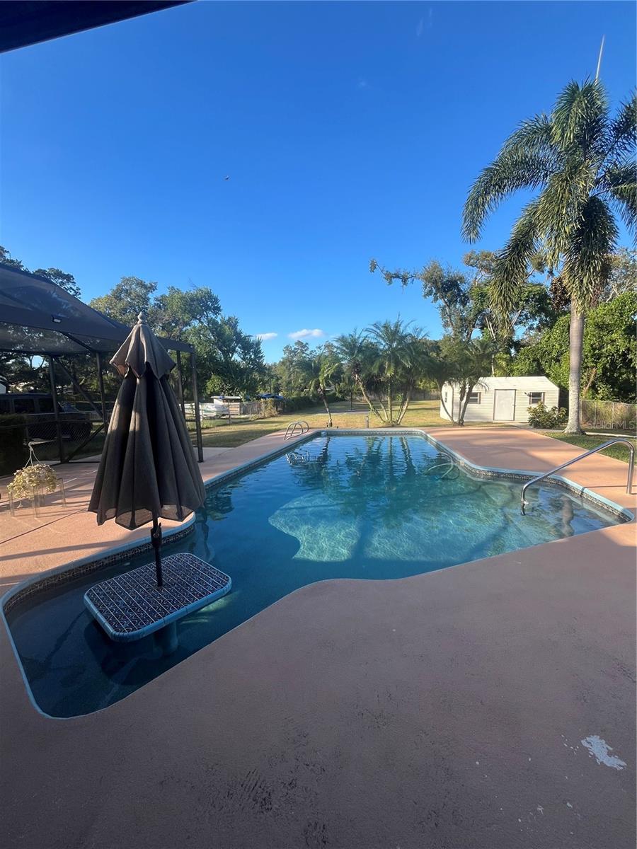 Pool has a table and stools